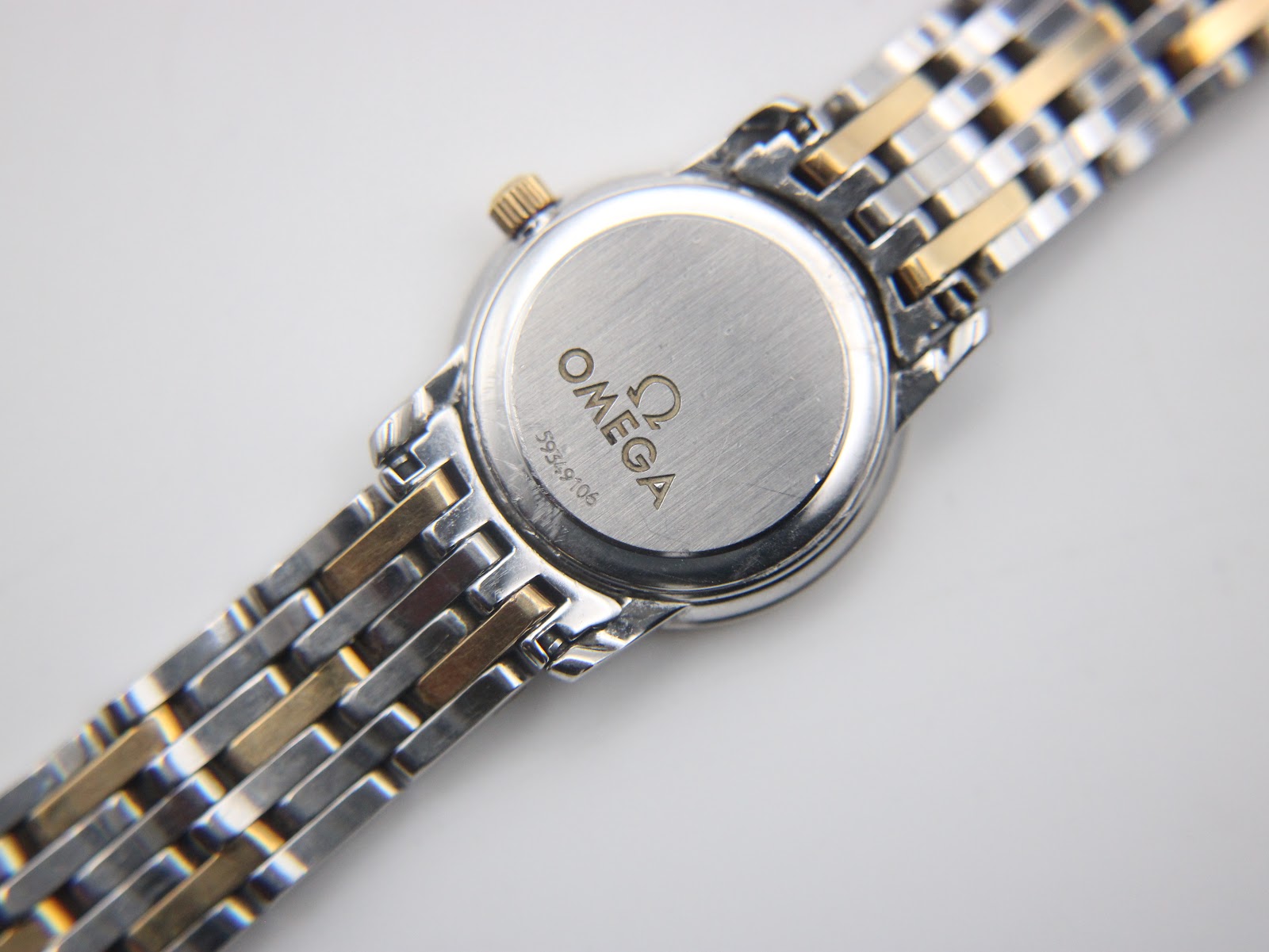 View of the Omega watch case back with serial number 59349106 and the two-tone bracelet.