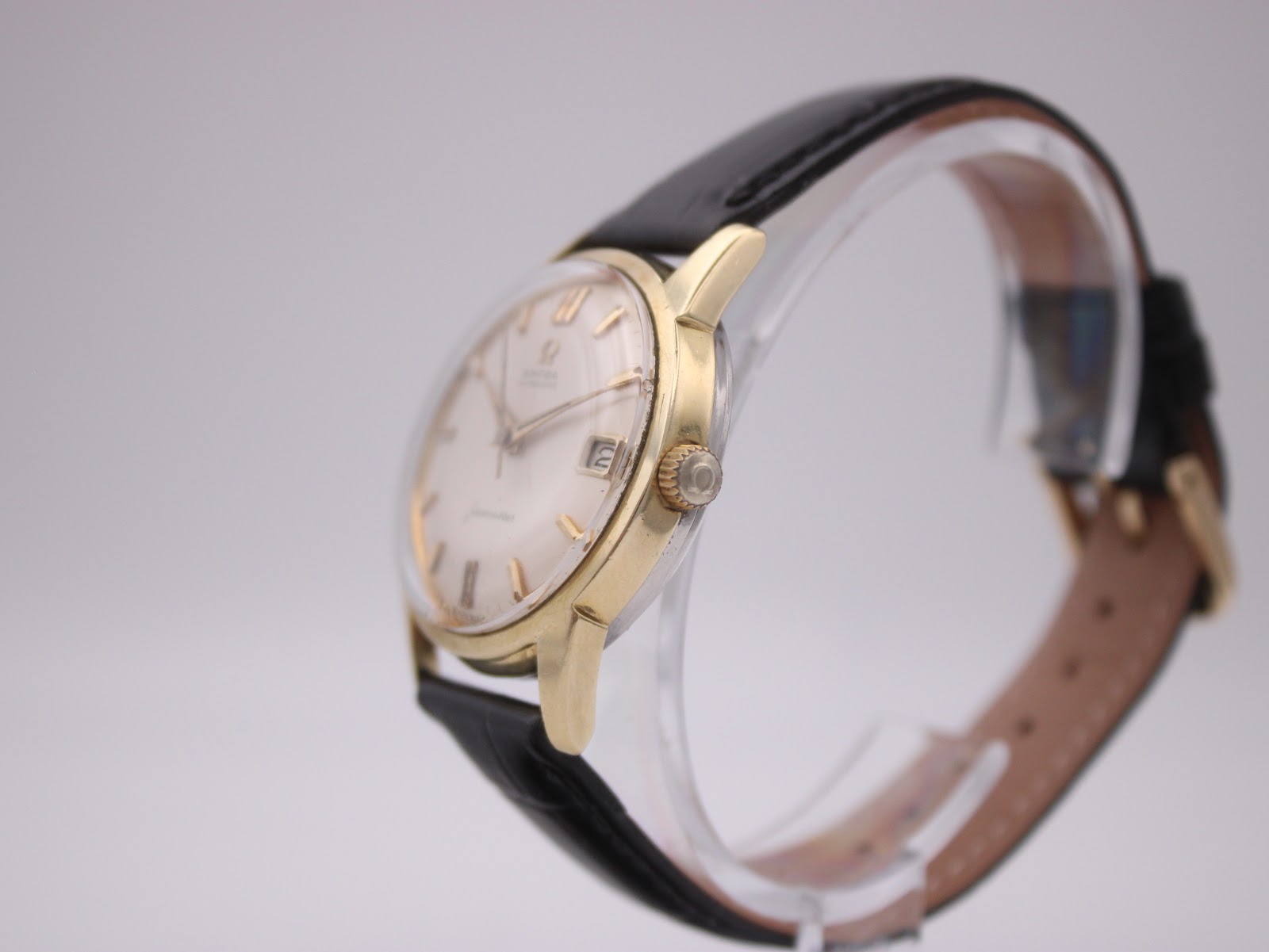 Side view of the omega seamaster watch, showing the gold-toned case and crown from the right.