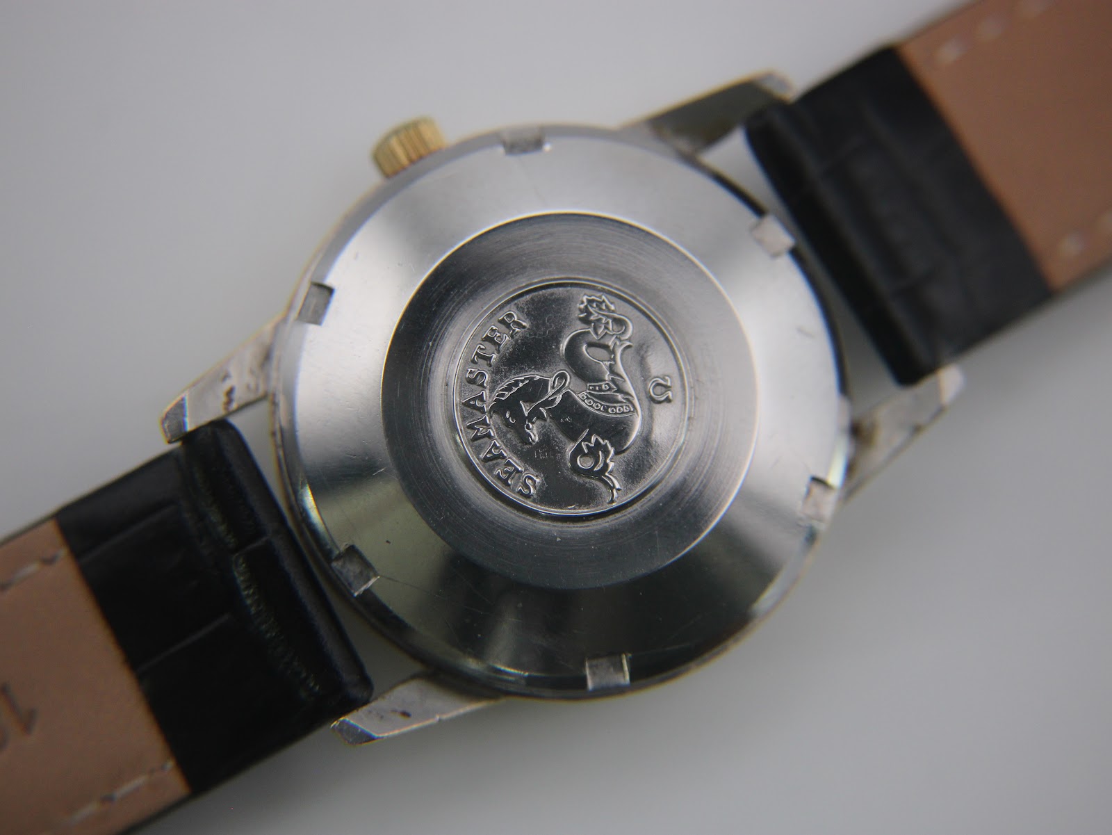 Close-up of the stainless steel case back with omega seamaster seahorse emblem.