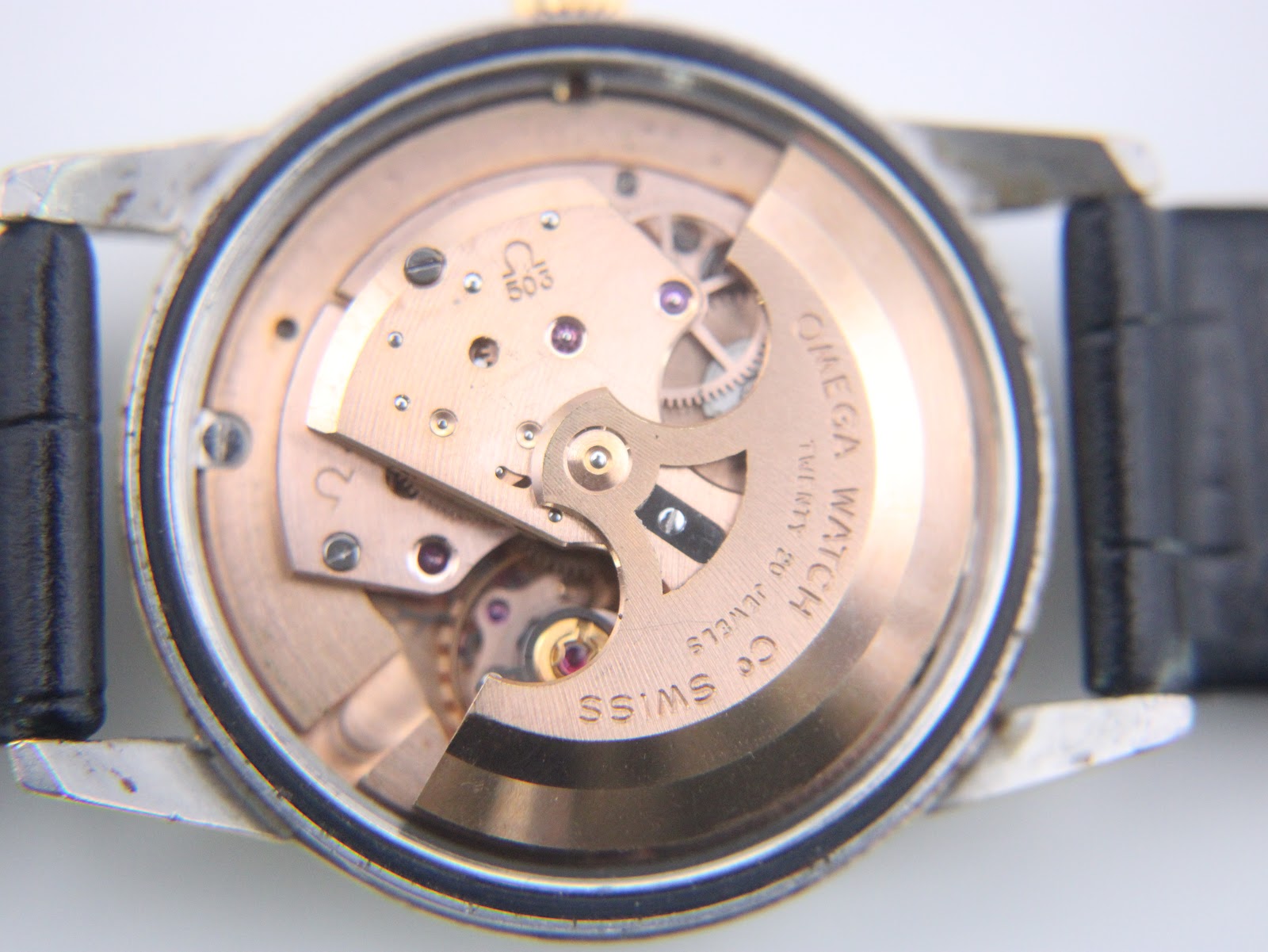 Interior view of the automatic omega movement, calibre 503, with 'omega watch twenty jewels swiss made' engraving.
