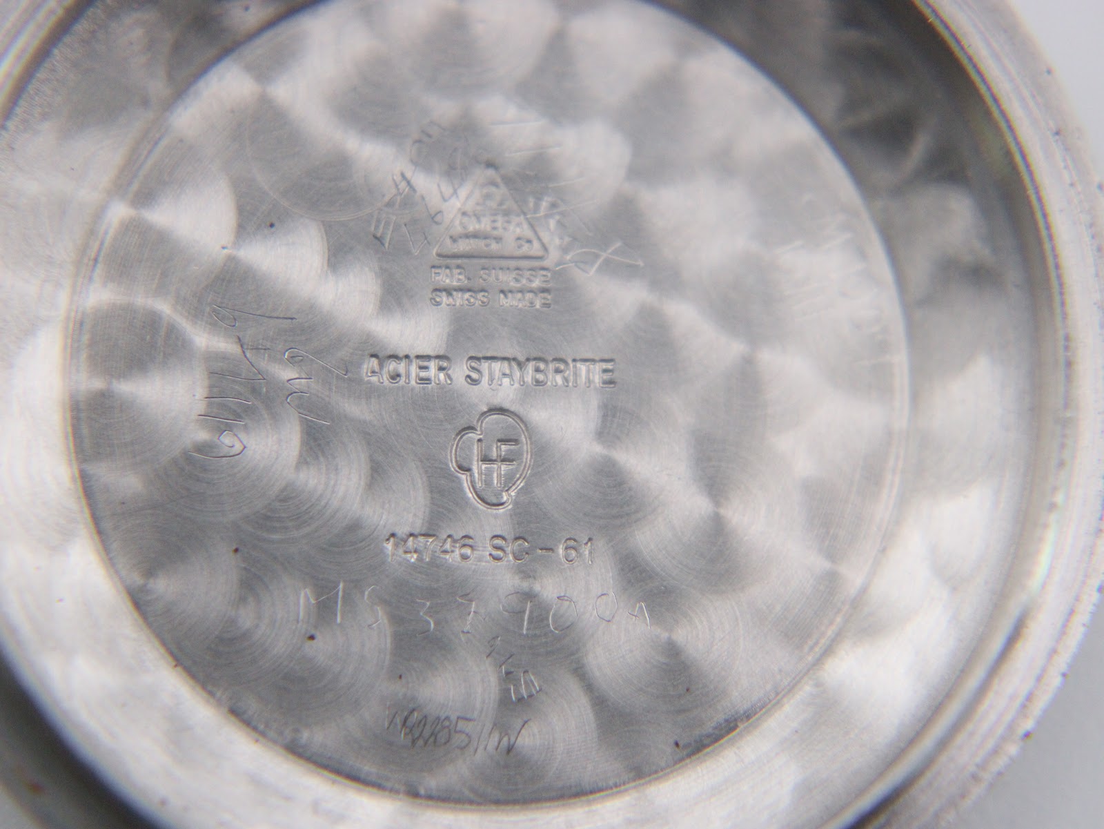 Inner case back showing 'omega fab. suisse swiss made acier staybrite' and reference number '14746 sc-61'.