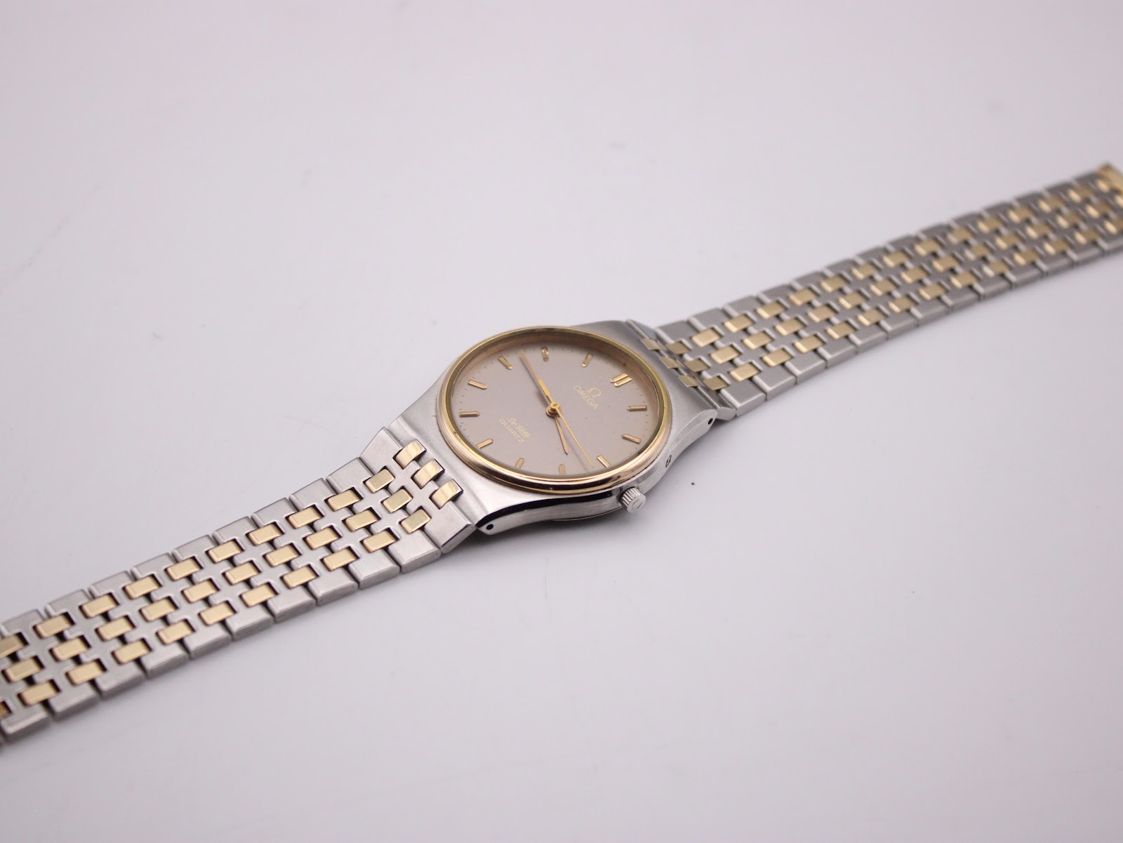 Full length view of the Omega De Ville two-tone bracelet and watch head on a white background.