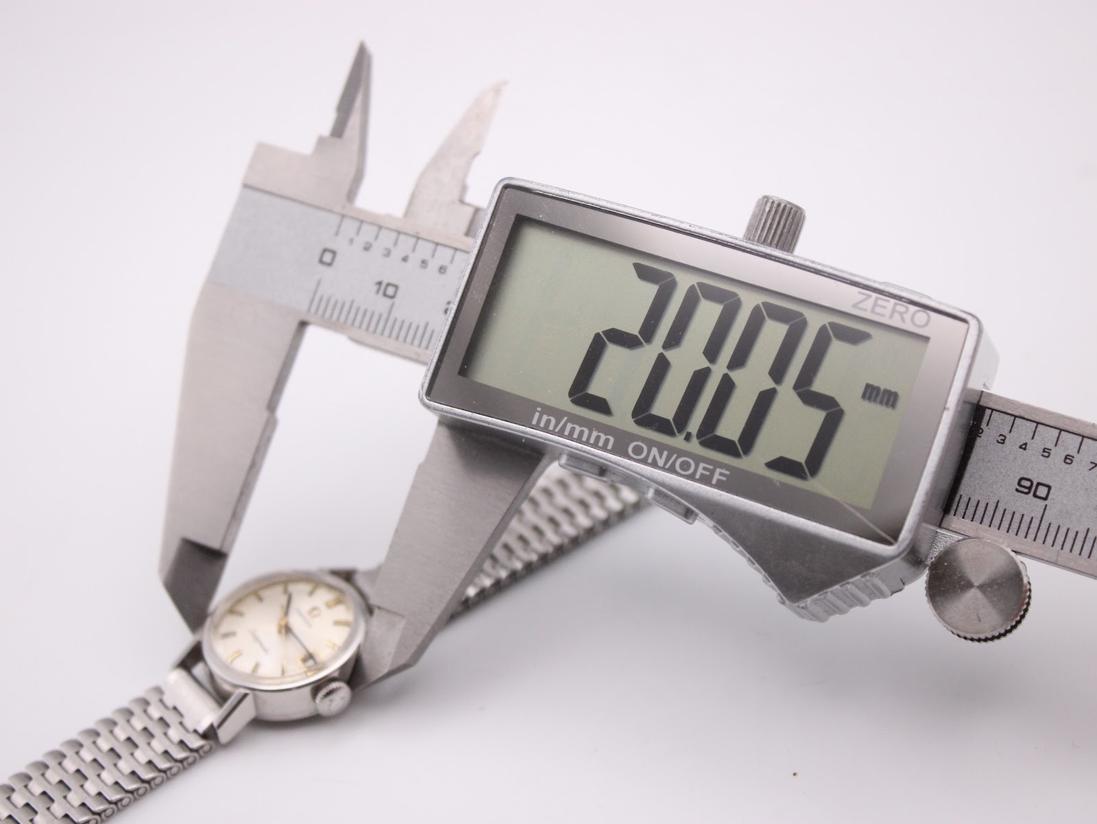 Digital caliper measuring the case diameter of the Omega Ladymatic watch, displaying an exact measurement of 20.05mm.