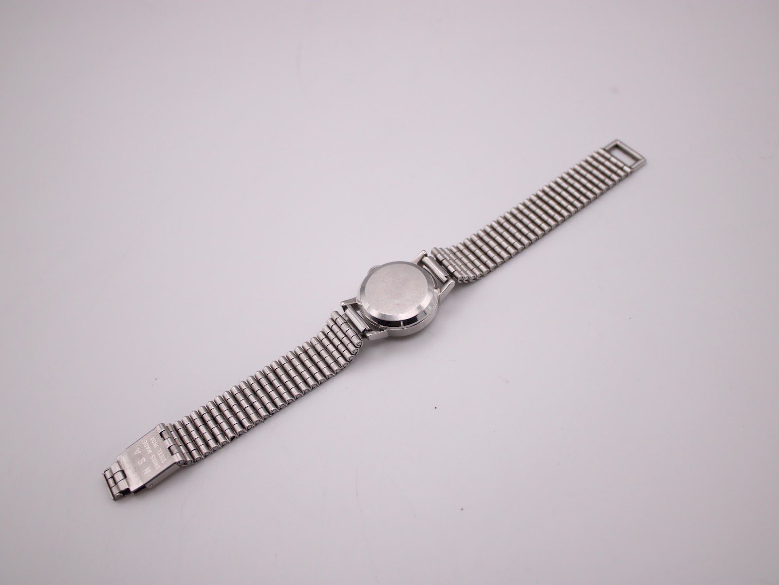 Rear view of the Omega Ladymatic watch with its case back and extended stainless steel bracelet.