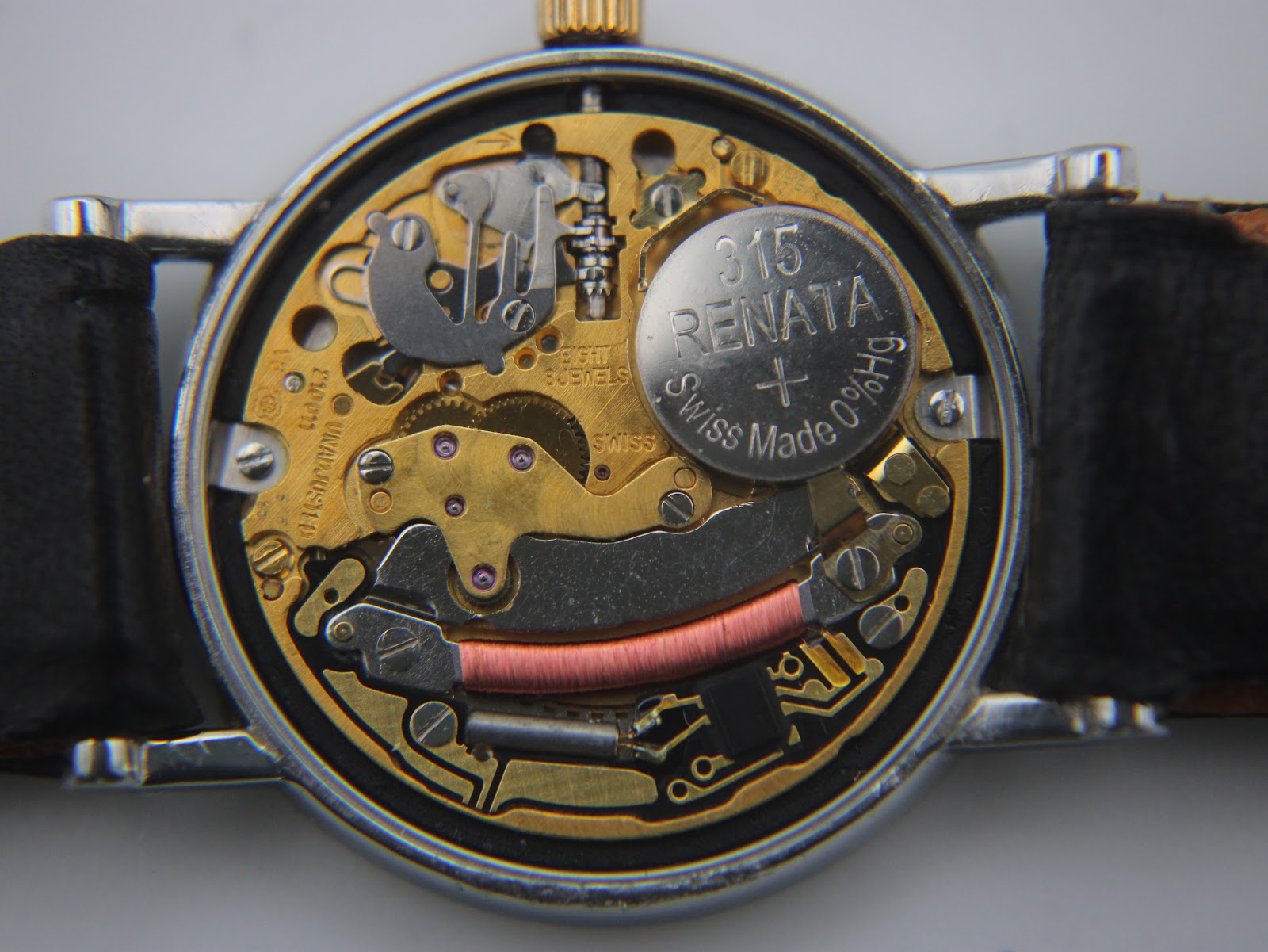 Detailed close-up of the Omega Swiss quartz movement inside the watch, with a Renata battery visible.