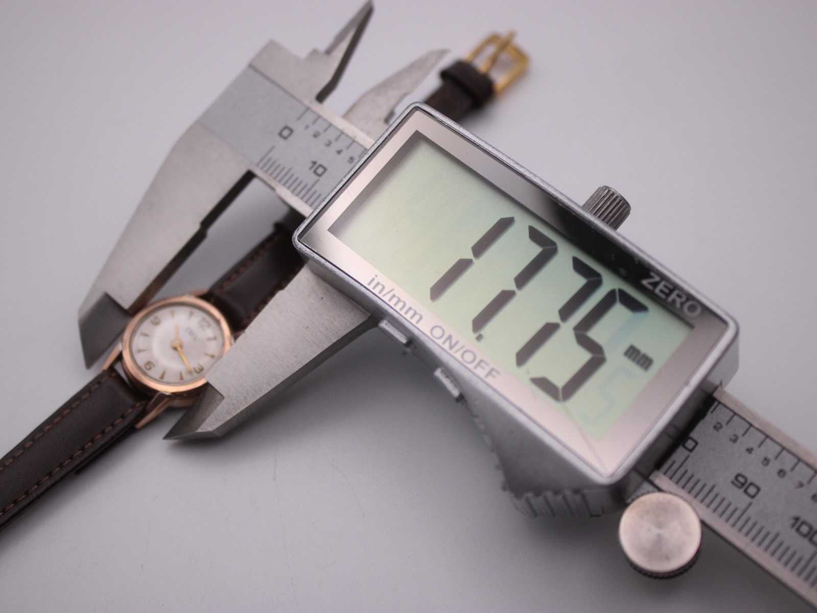 Close-up of a digital caliper measuring the watch case diameter at 17.75mm.