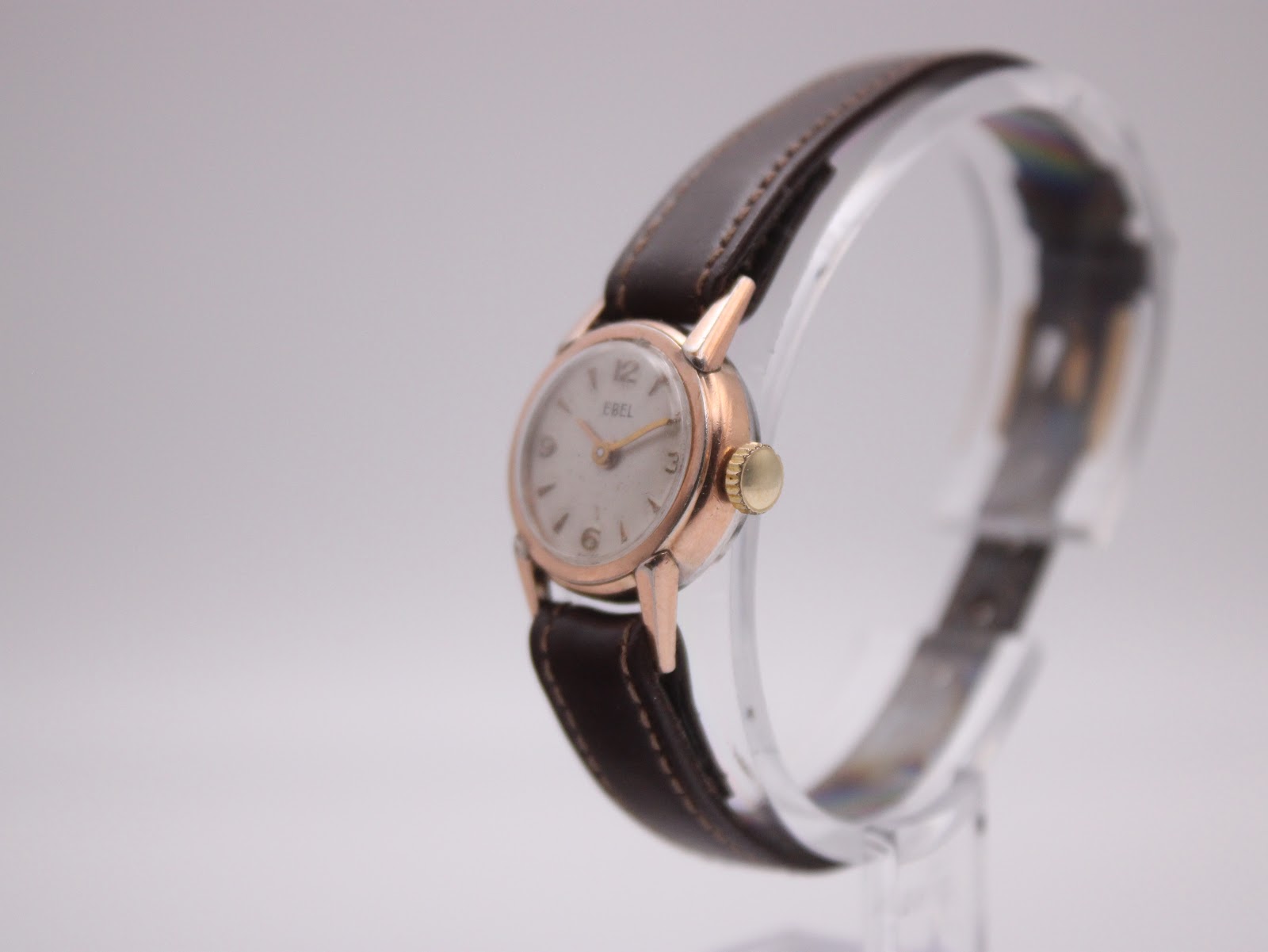Angled side view of the EBEL watch, highlighting the domed crystal and gold-tone crown.