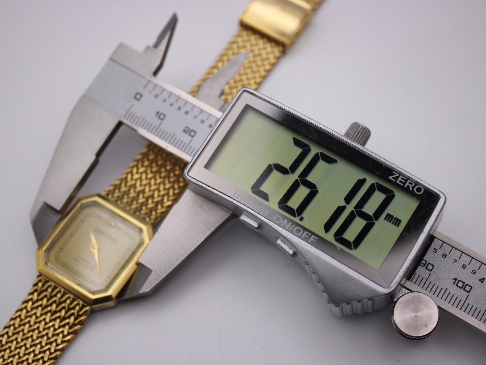 Digital caliper measuring the Santima watch case, displaying an exact diameter of 26.18 mm.