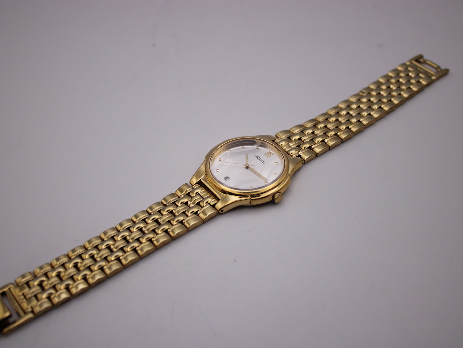 Overhead view of the Seiko gold-tone watch laid flat, displaying the full length of the integrated bracelet.
