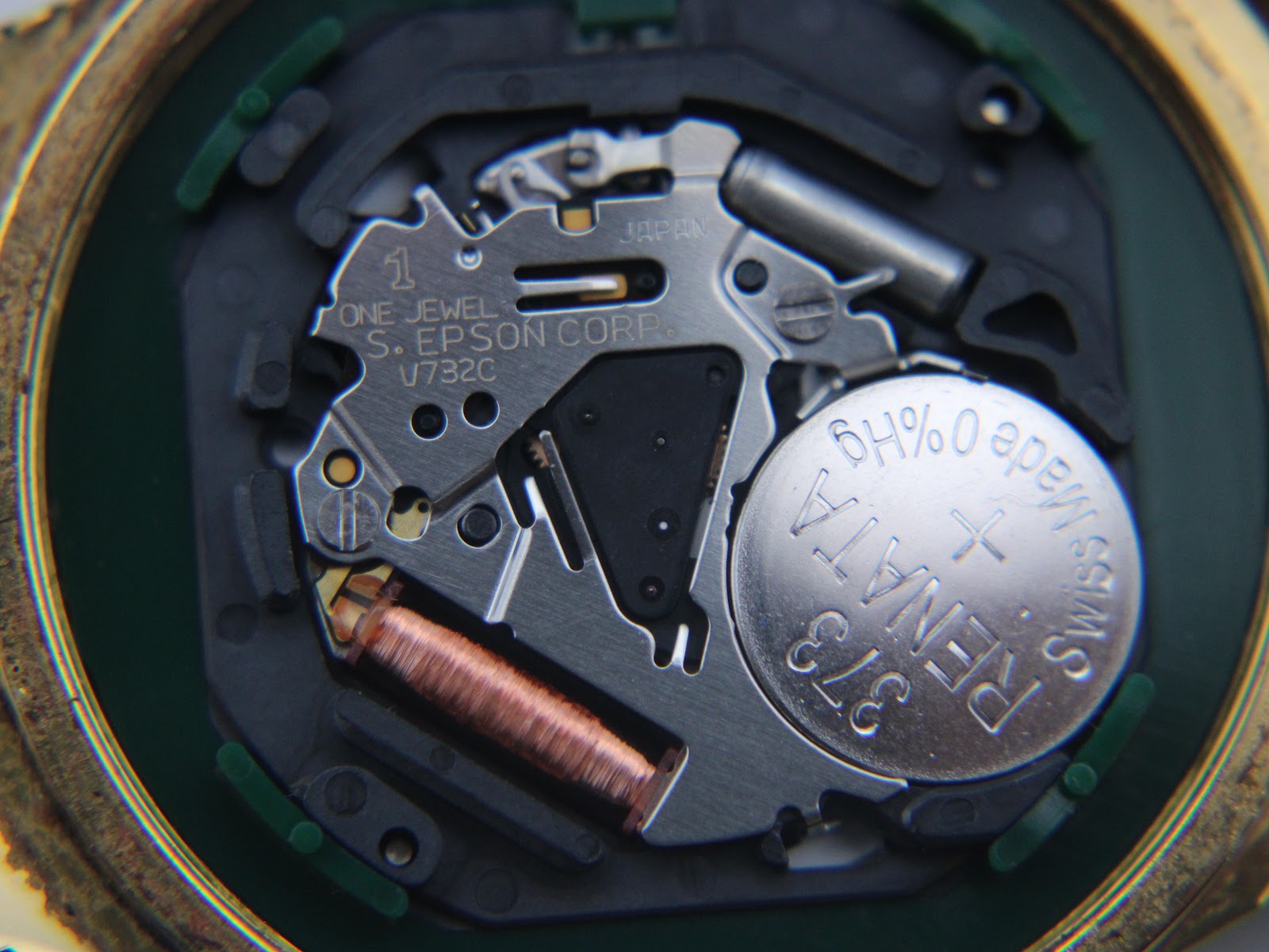 Close-up of the Seiko V732C quartz movement with a Renata 373 battery installed, showing internal components.