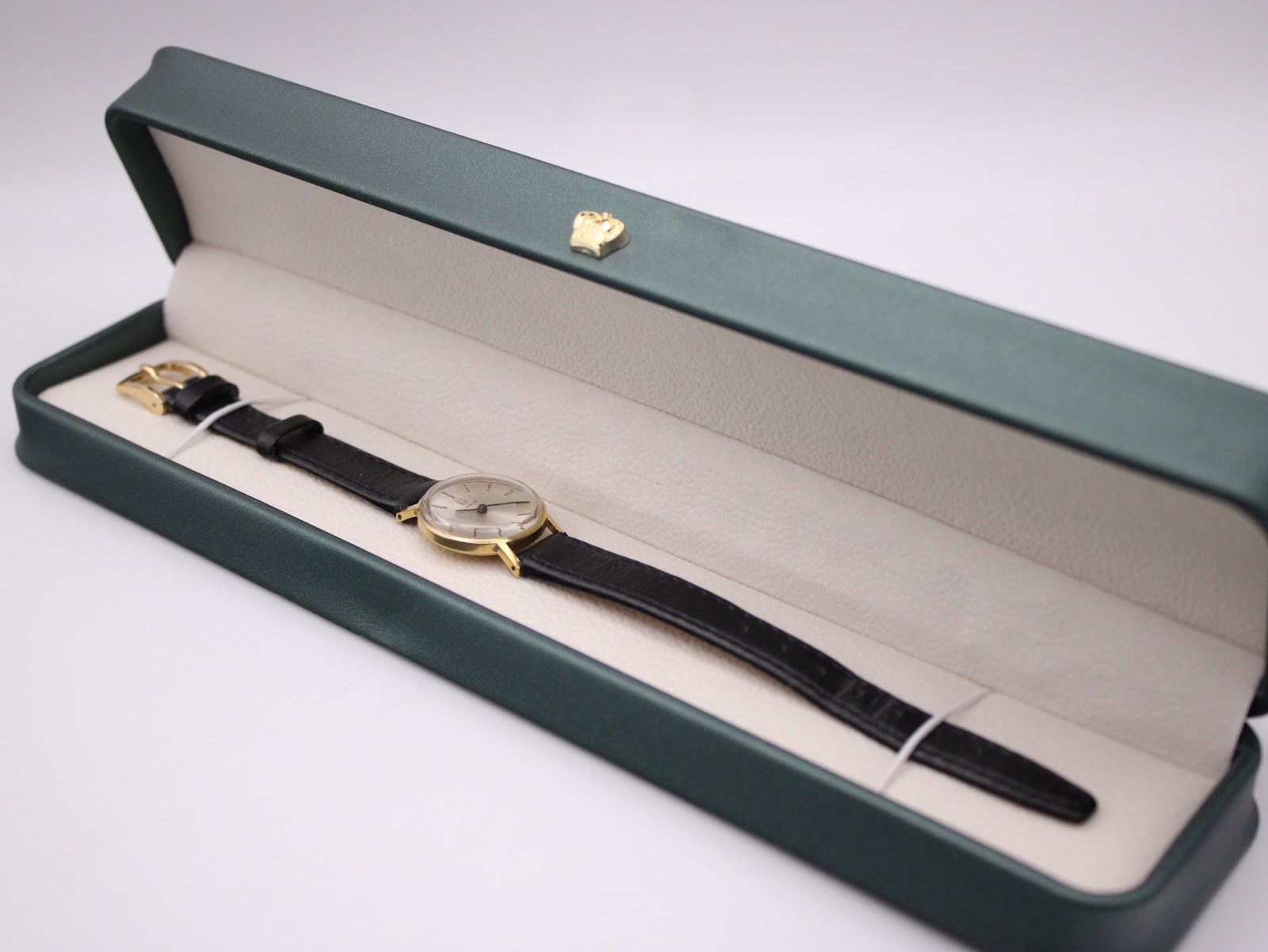 The vintage Tissot watch presented inside its original green Tissot presentation box, with the strap laid neatly.
