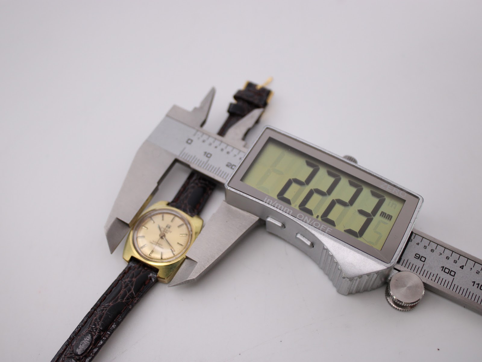 Digital caliper measuring the Tissot watch case diameter at precisely 22.23mm.