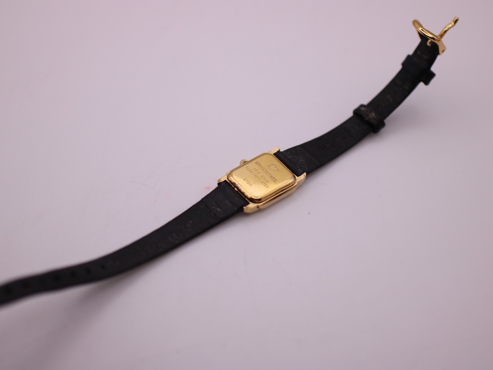 Rear view of the Raymond Weil watch, showing the case back and the full length of the black leather strap.