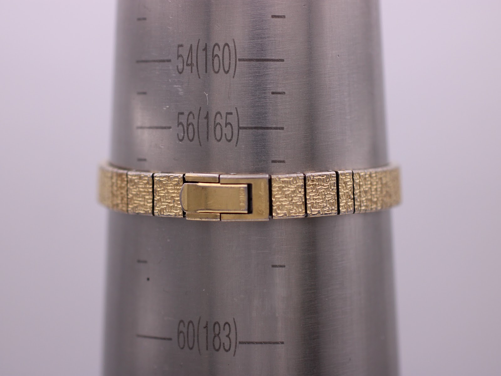 Seiko Rainbow watch bracelet wrapped around a wrist sizing cone, showing a size marking of 165mm.