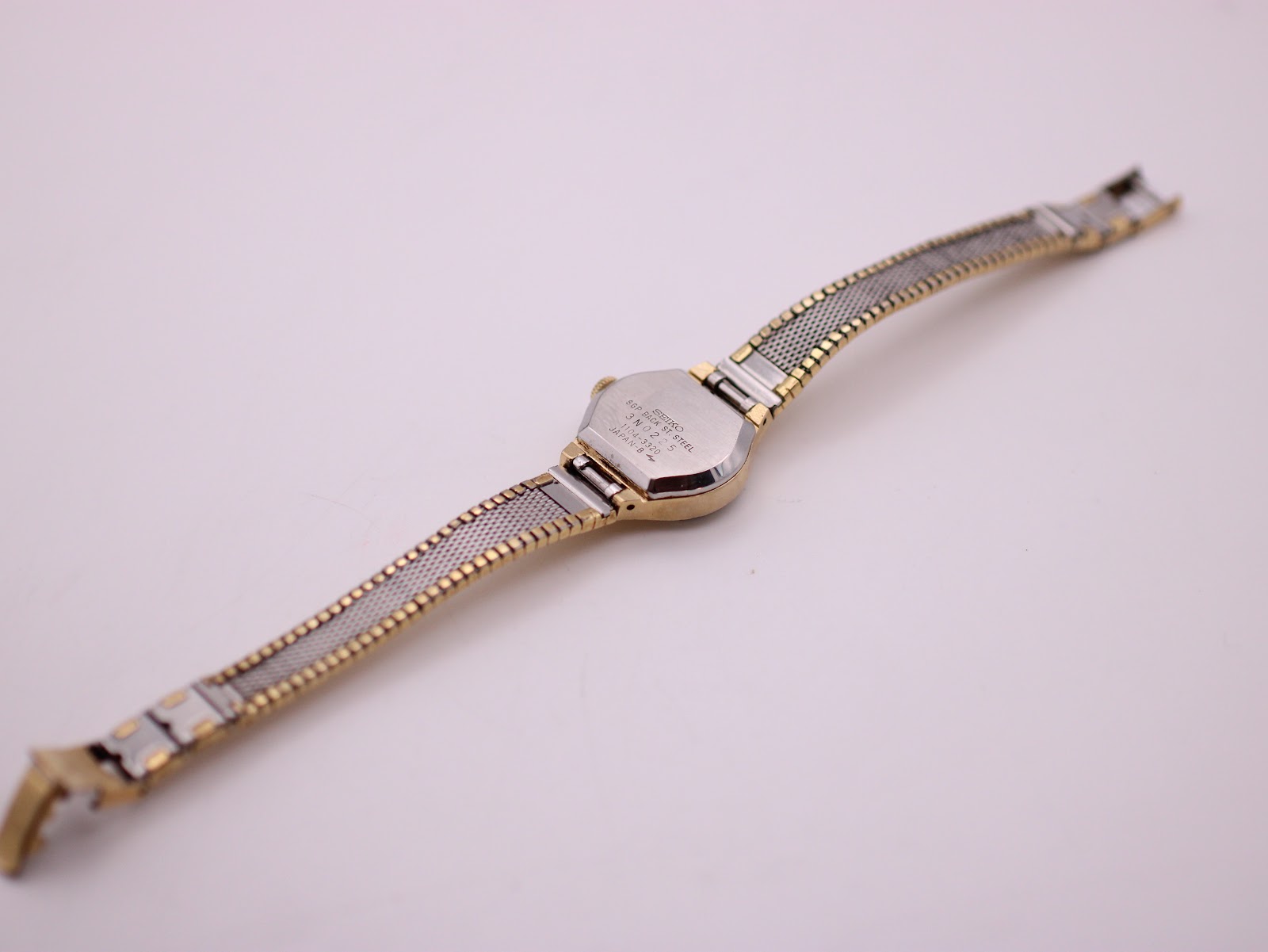 Back view of the Seiko Rainbow watch showing the stainless steel case back and the two-tone gold and silver coloured mesh bracelet.