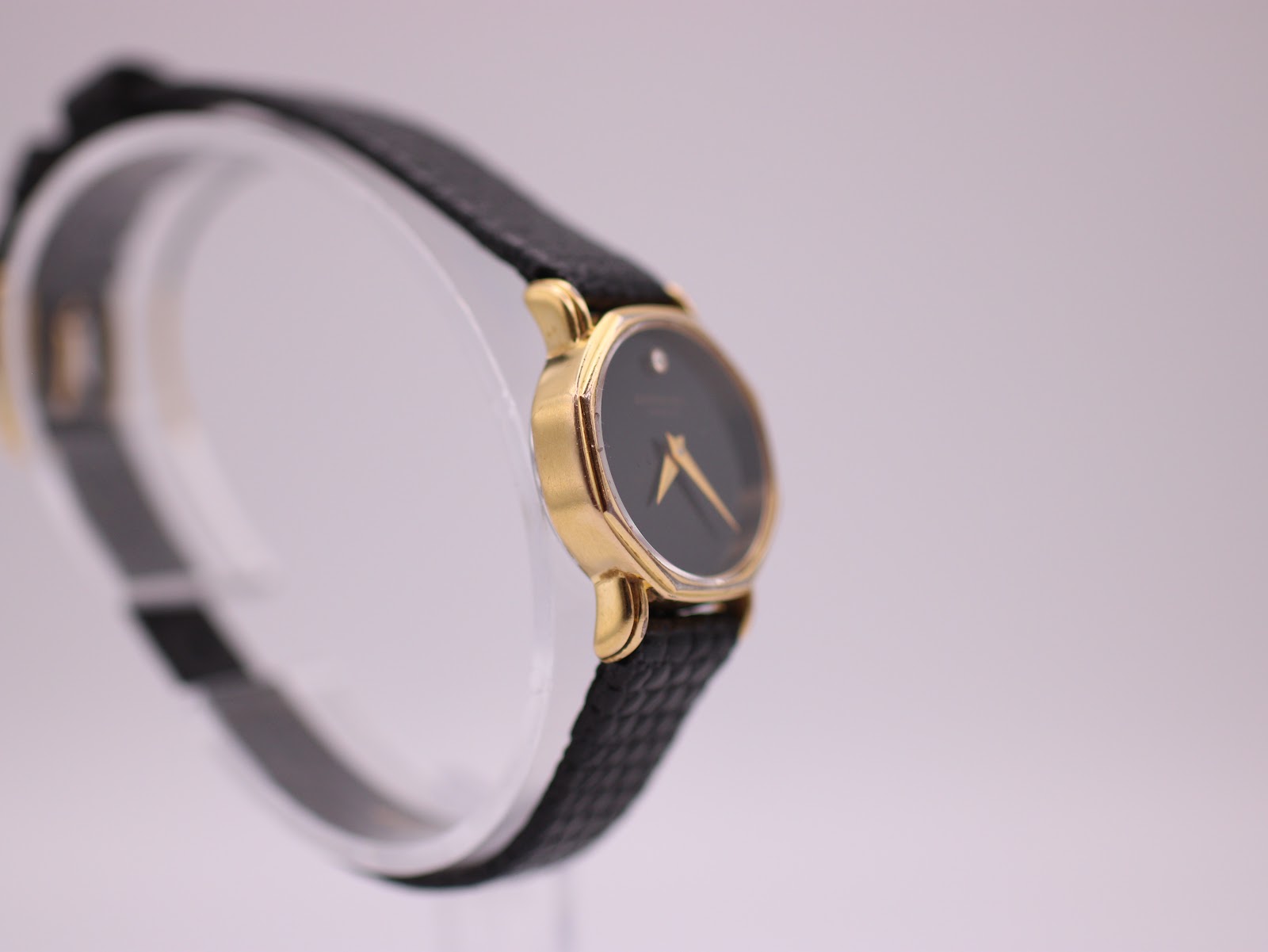 Another side profile of the Raymond Weil 570 watch, highlighting its slim case on a display stand.