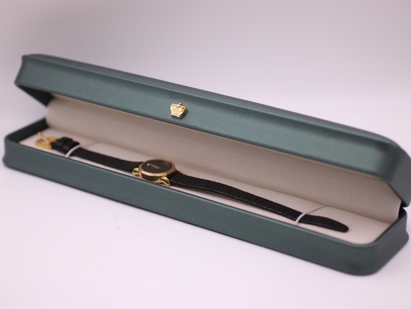 The Raymond Weil 570 watch presented inside its original dark green rectangular box with a cream interior.