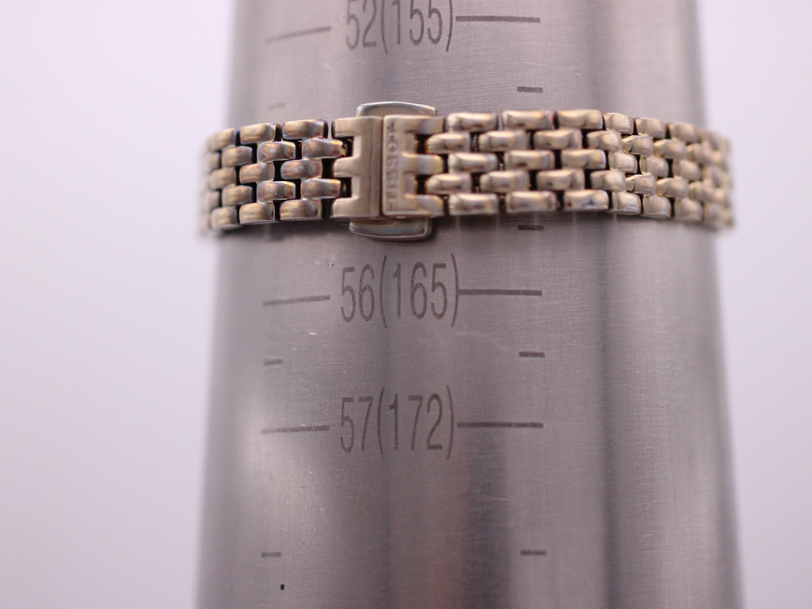 The Tissot watch's bracelet fastened around a wrist sizing cone, indicating a wrist circumference of 165mm / 16.5cm.
