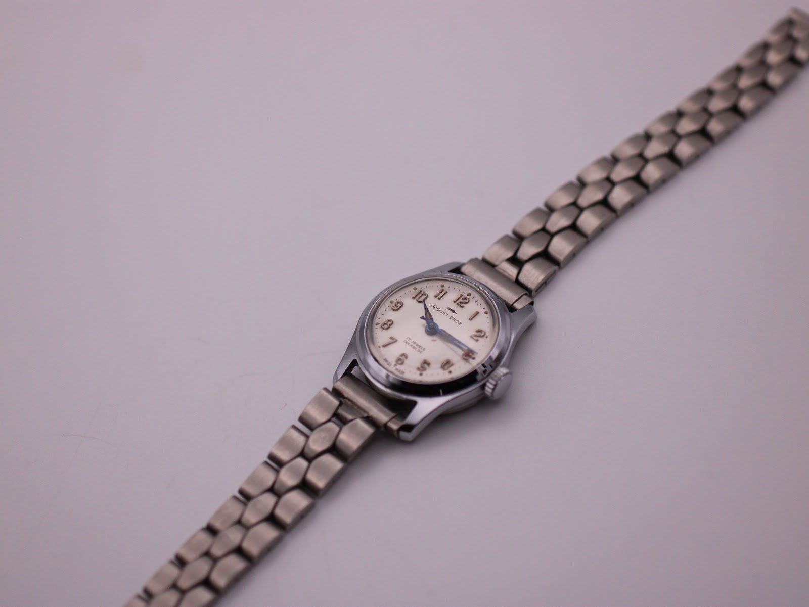 Overhead view of the Jaquet-Droz watch laid flat, displaying the full steel bracelet.