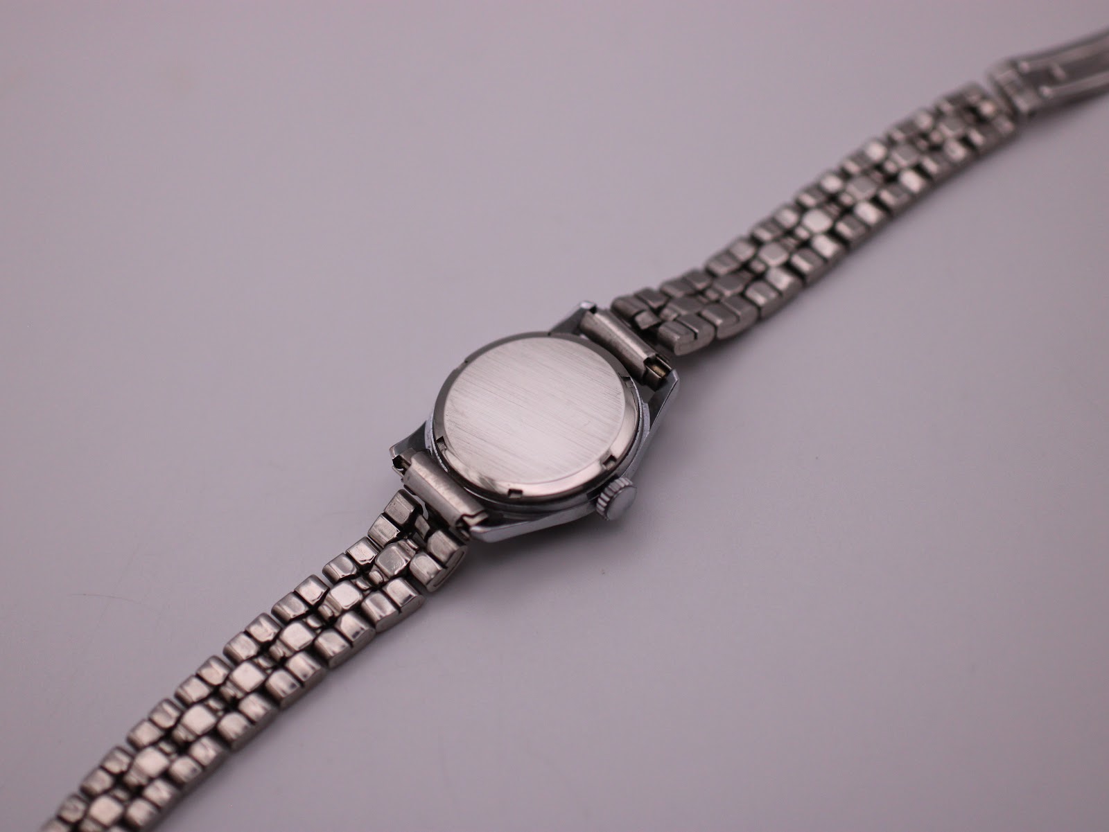 Back view of the Jaquet-Droz watch showing the brushed steel case back and the integrated bracelet.