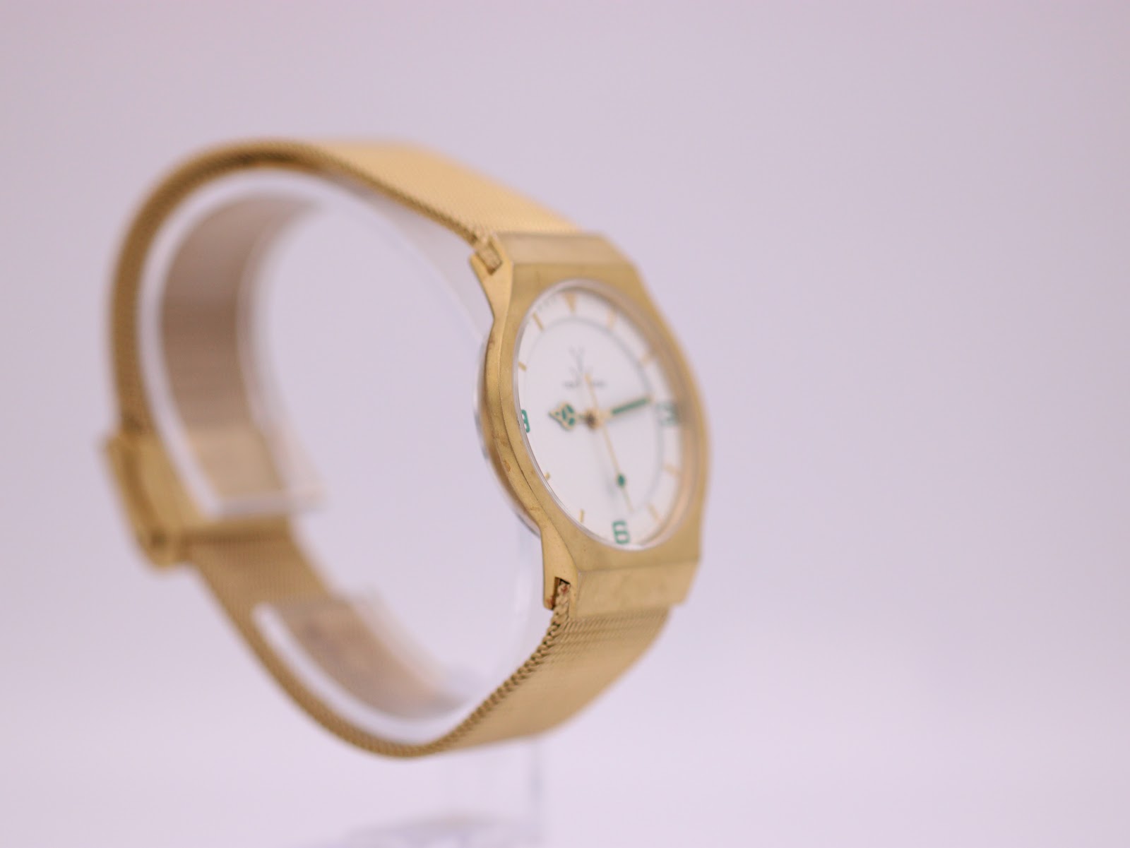 Another angled side view of the Toy Watch on a clear stand, highlighting its slim profile.