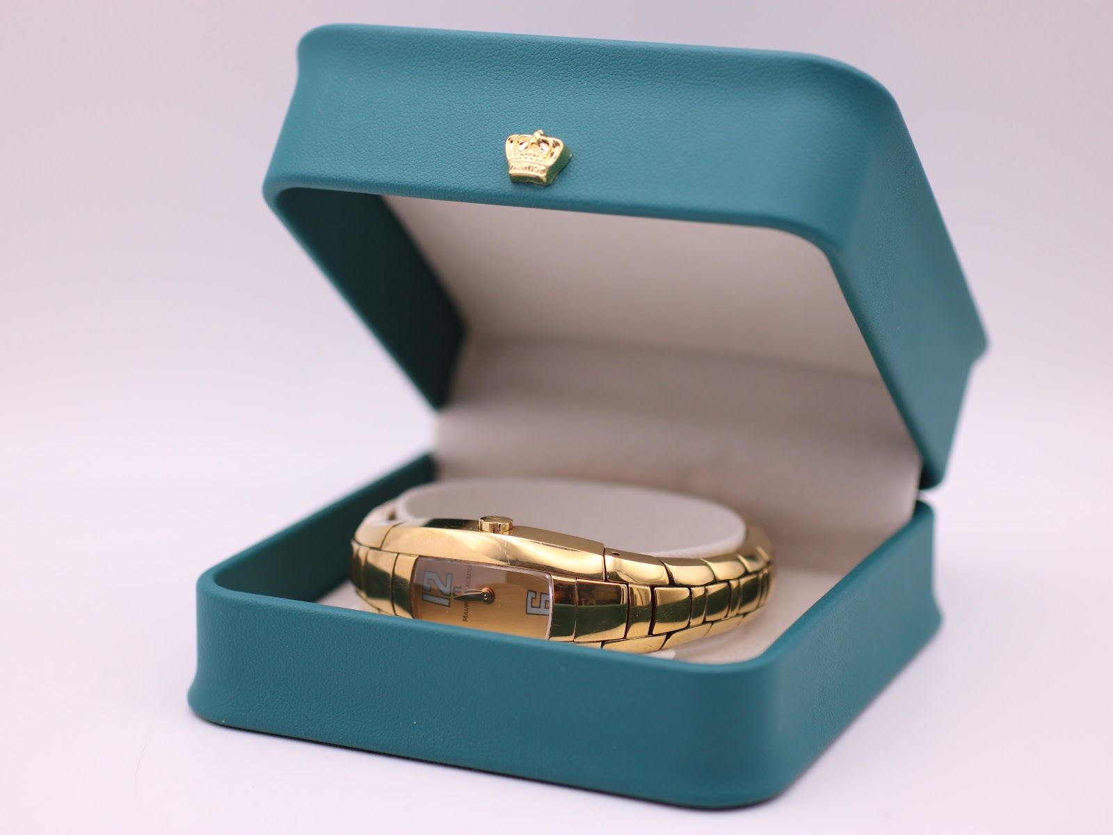 The Maurice Lacroix IN3012 gold-plated watch displayed open in its original turquoise presentation box.