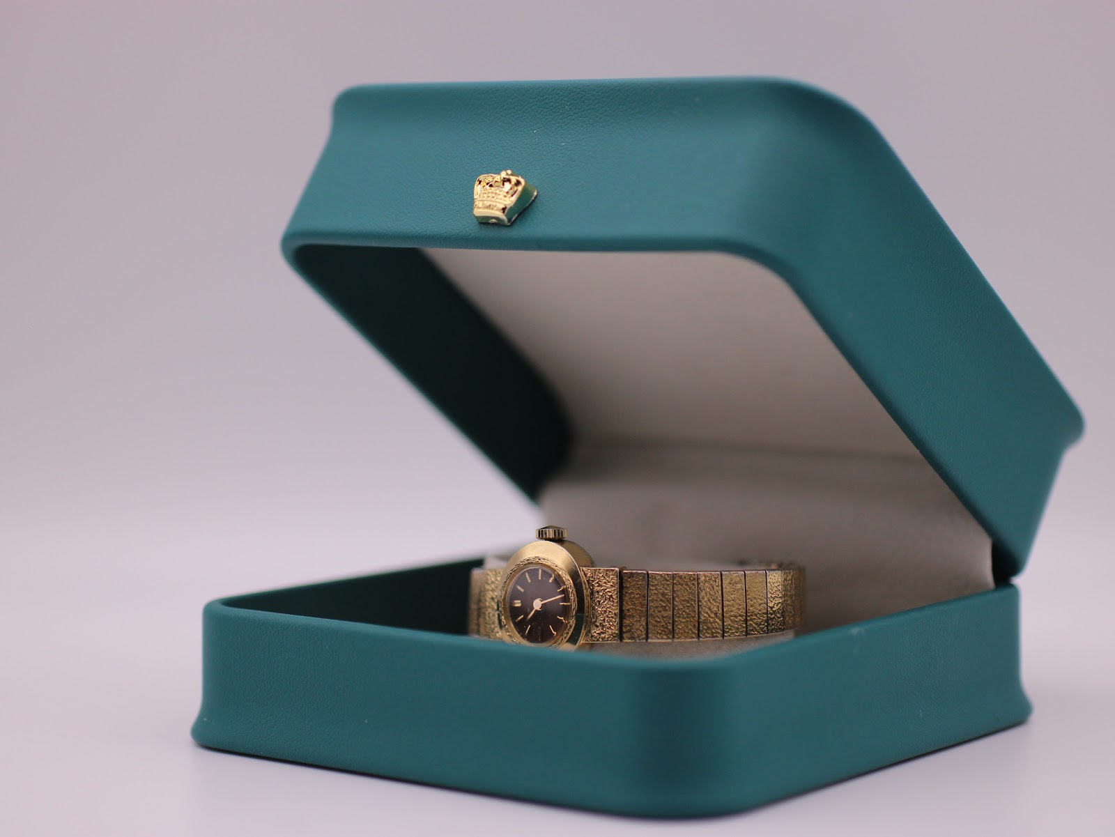The Seiko watch nestled in its original teal-coloured presentation box with a golden crown emblem.