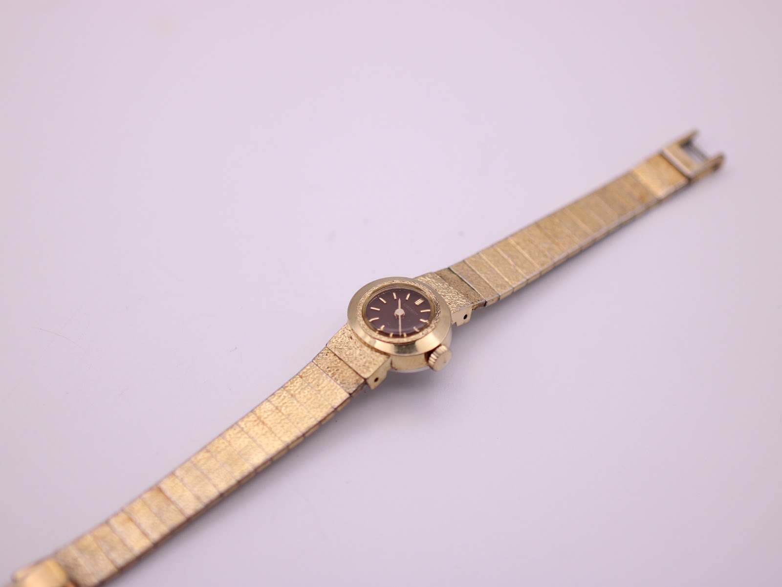 Overhead view of the entire gold-plated Seiko watch with its expanding bracelet stretched out.