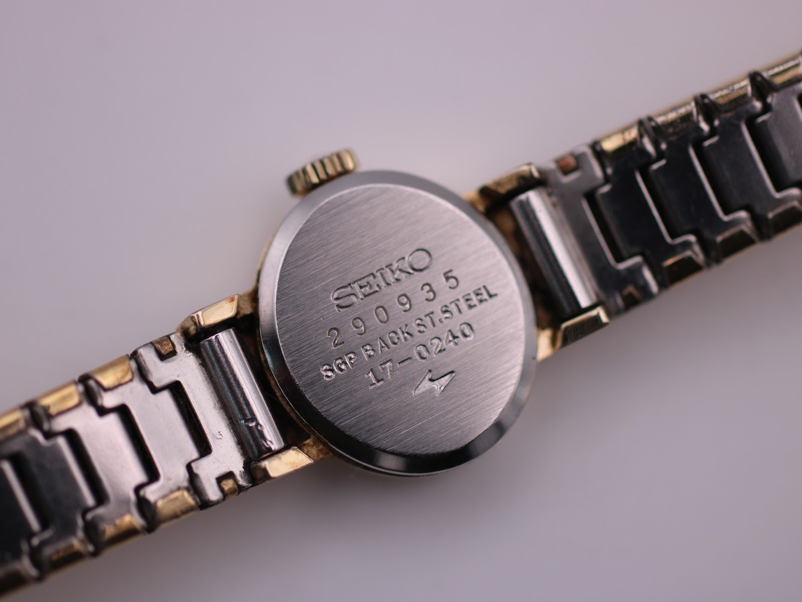 Close-up of the watch case back, clearly showing "SEIKO 290935 SGP BACK ST.STEEL 17-0240".
