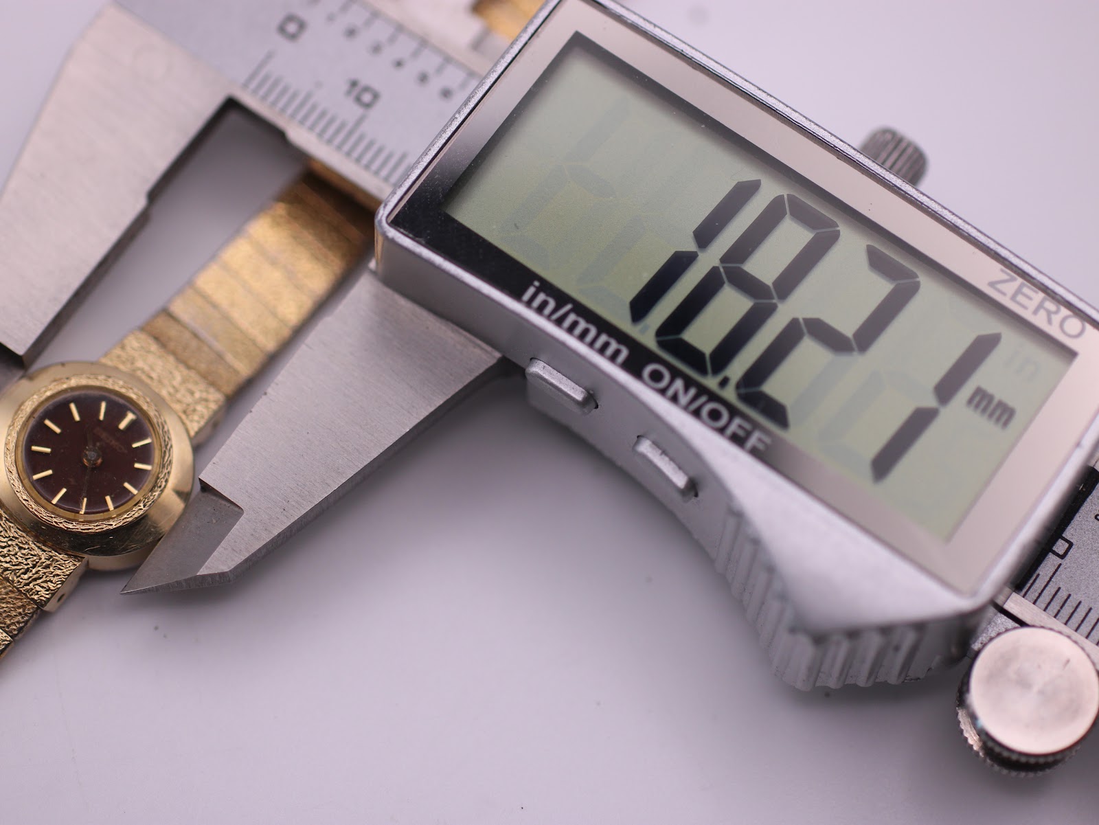 Digital caliper measuring the case diameter of the Seiko watch, displaying 18.2mm.