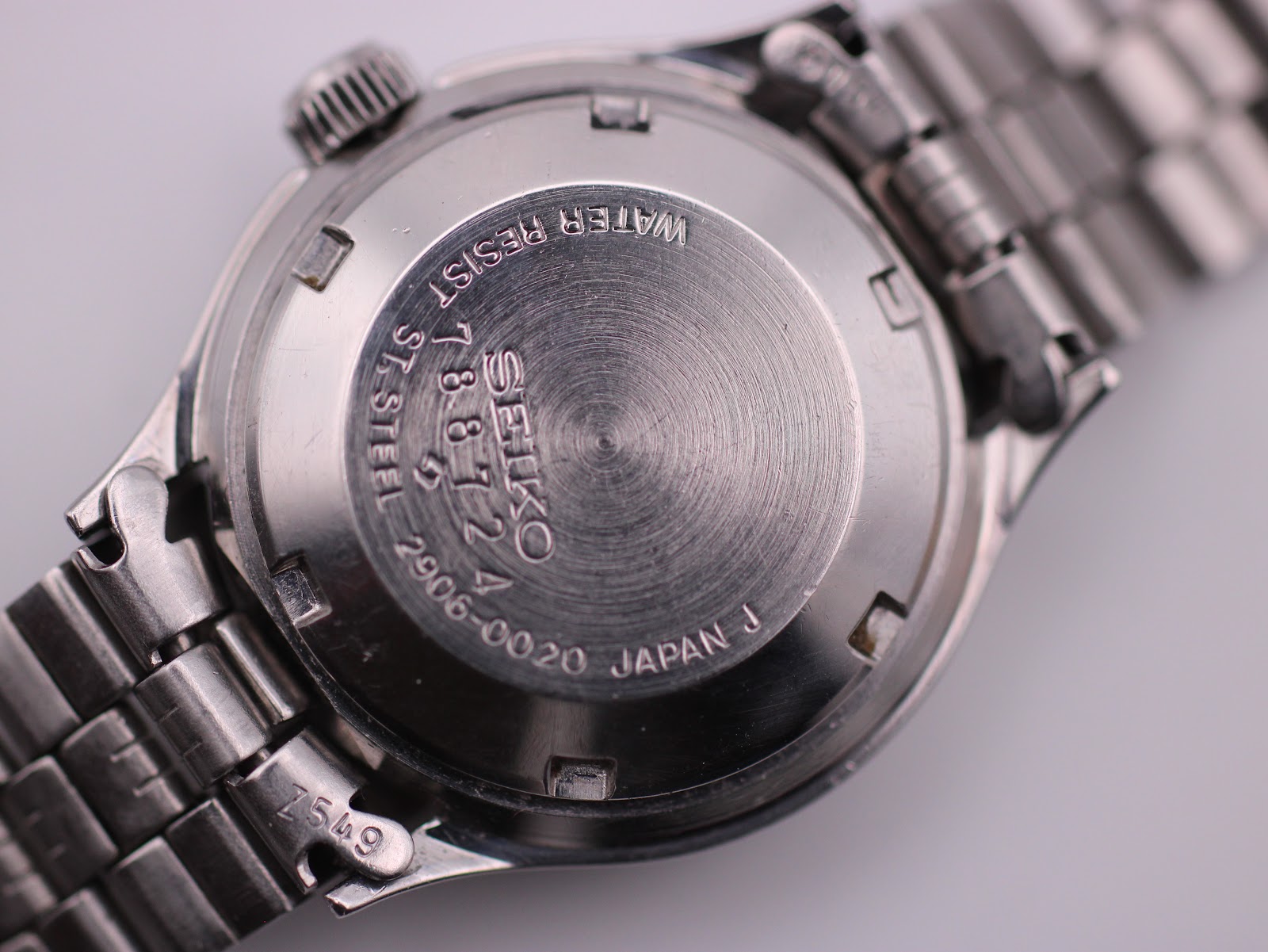 Detailed close-up of the stainless steel case back of the SEIKO 2906-0020, displaying model number, serial number, and 'WATER RESIST'.