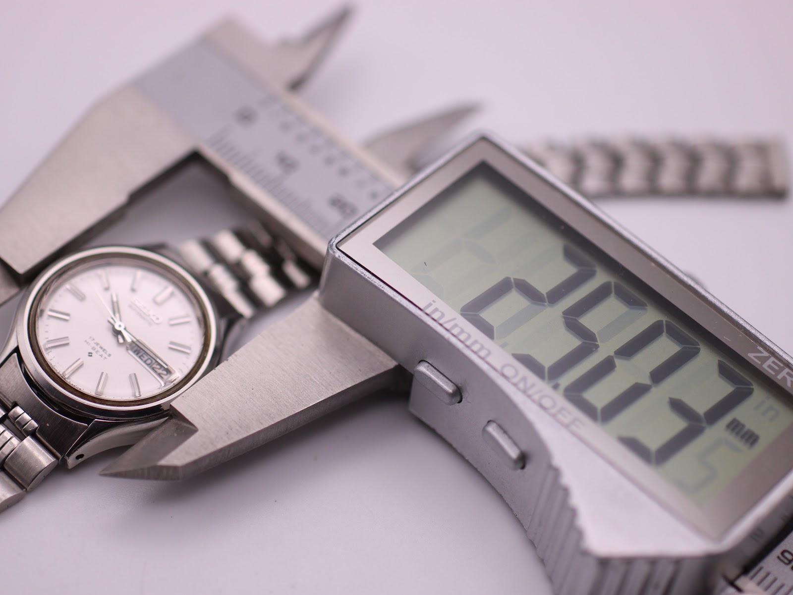 The SEIKO 2906-0020 watch being measured by a digital caliper, displaying a case size of 24.37mm.