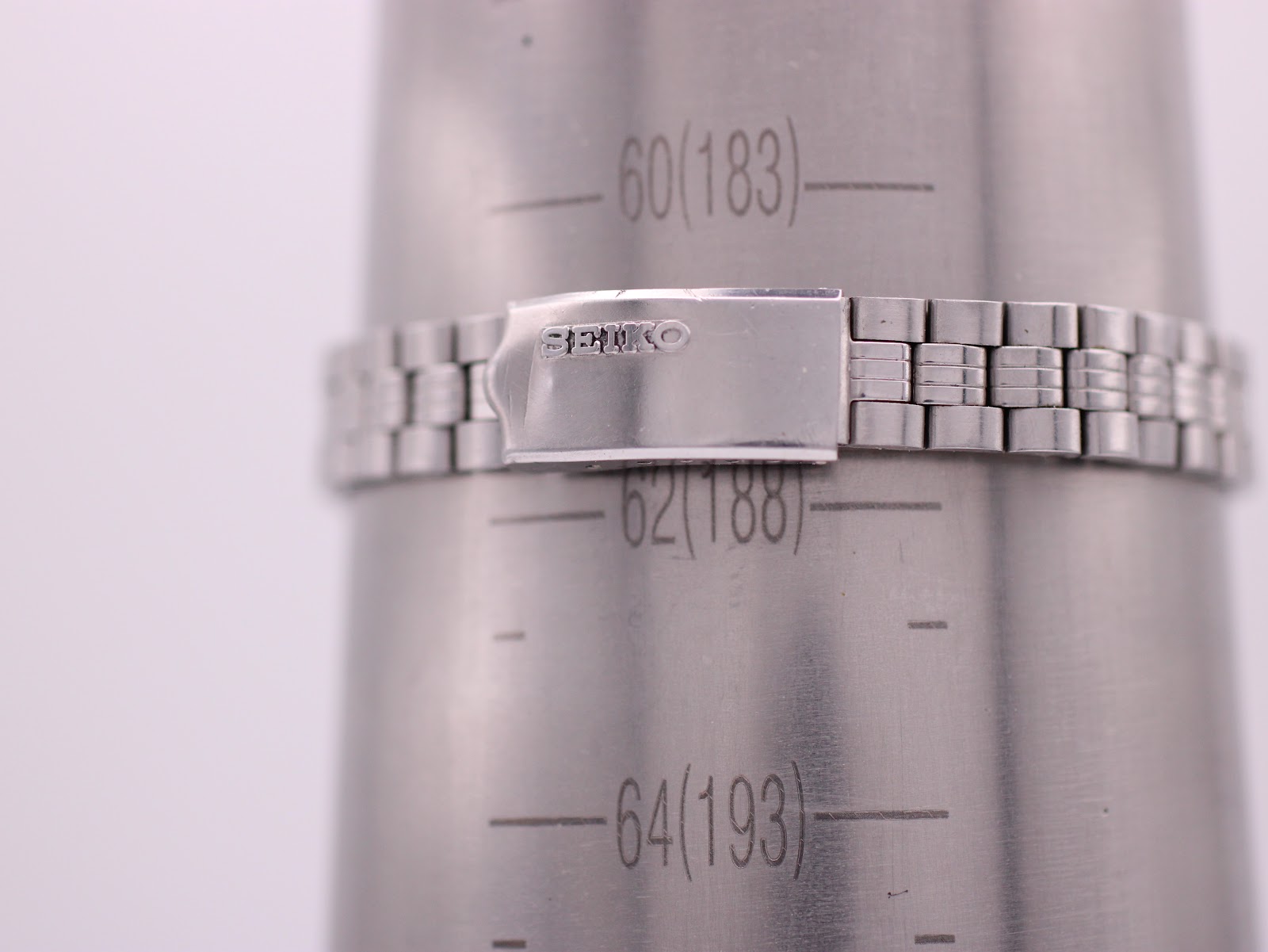 The SEIKO stainless steel bracelet with its signed "SEIKO" clasp on a wrist sizing gauge, indicating a maximum wrist circumference of 188mm.