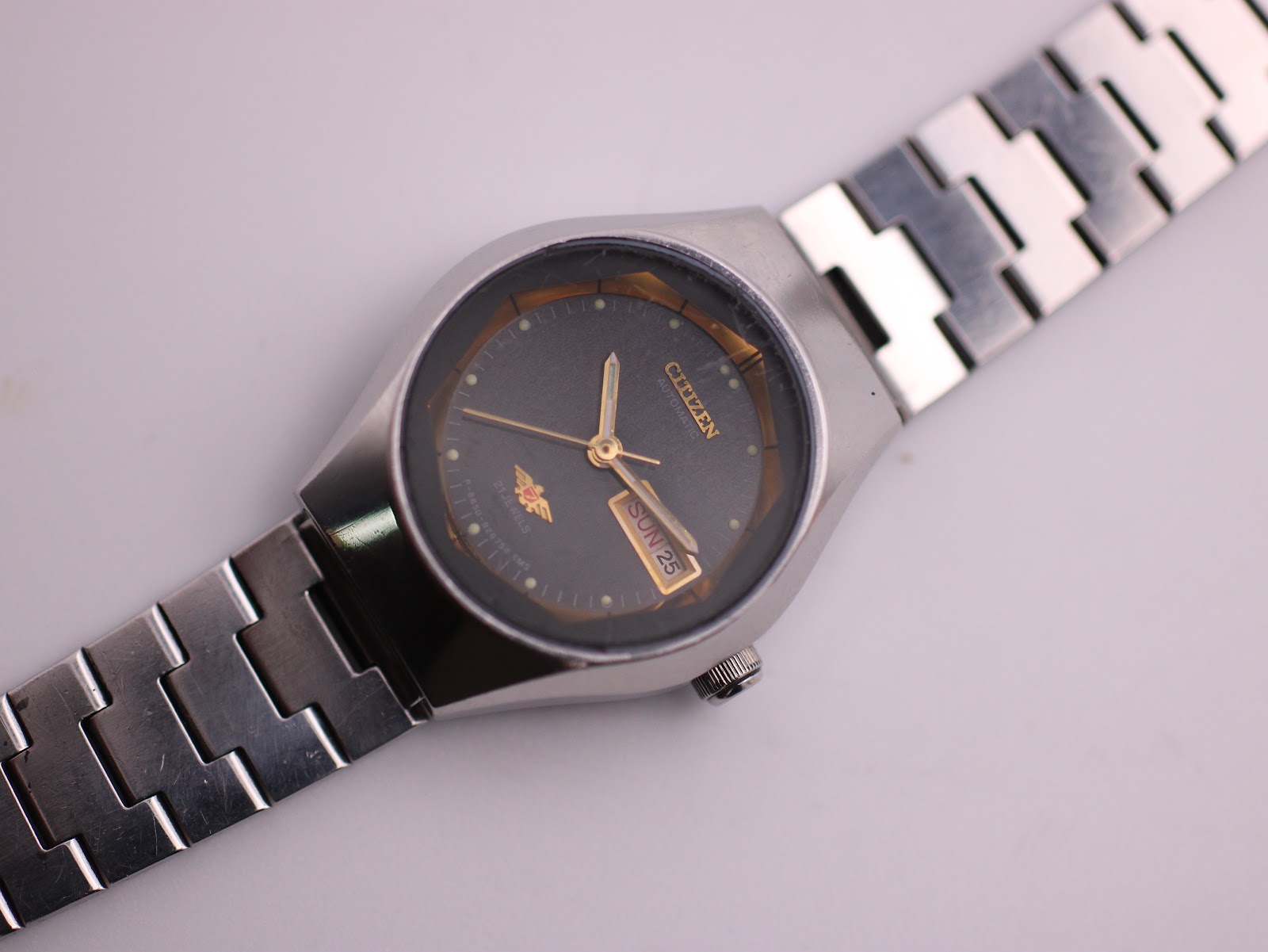 Top-down view of the Citizen 74-7491 watch on a white surface, highlighting the full steel bracelet.