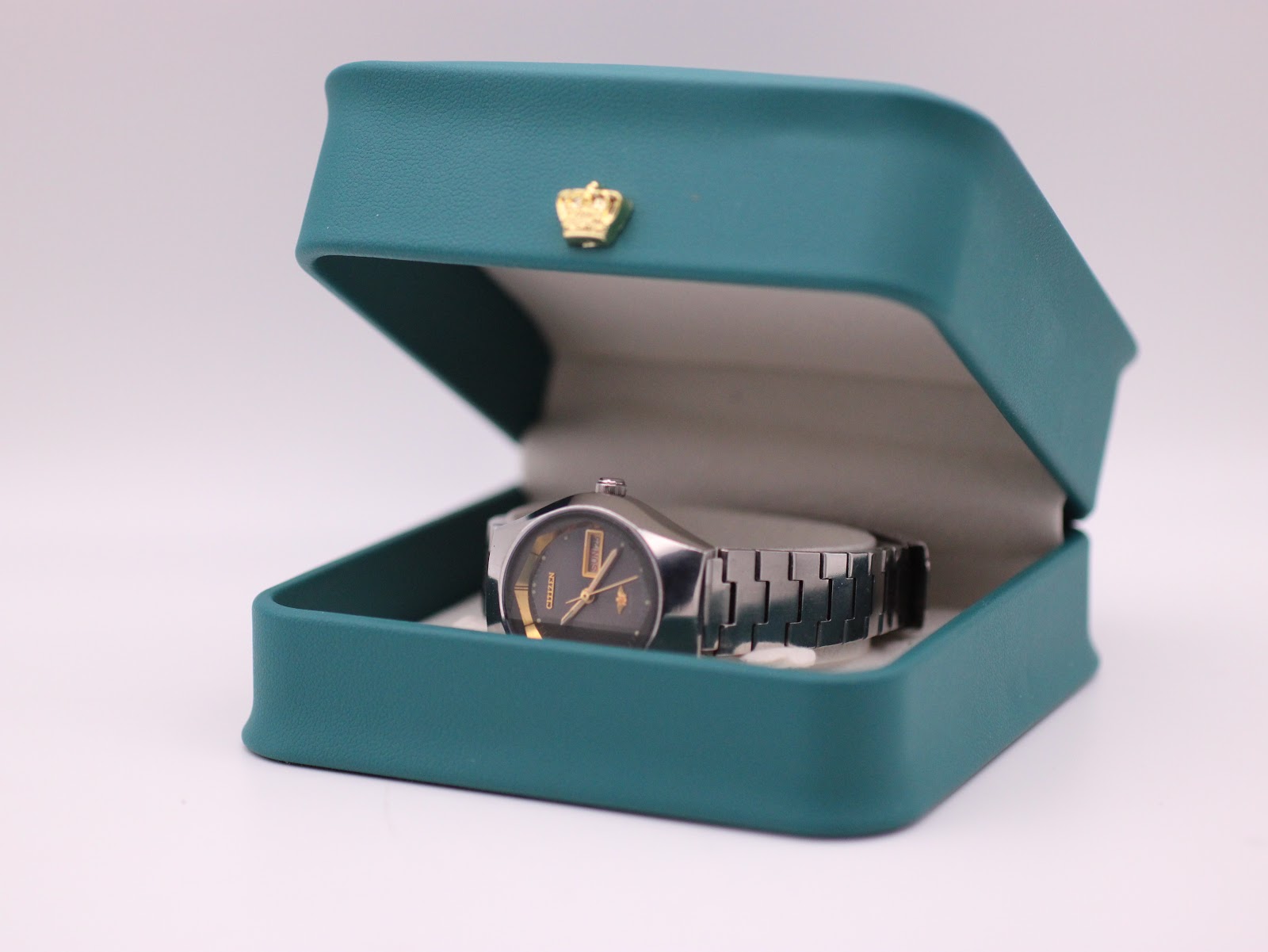 The Citizen watch displayed inside its original teal box with a small gold crown emblem.