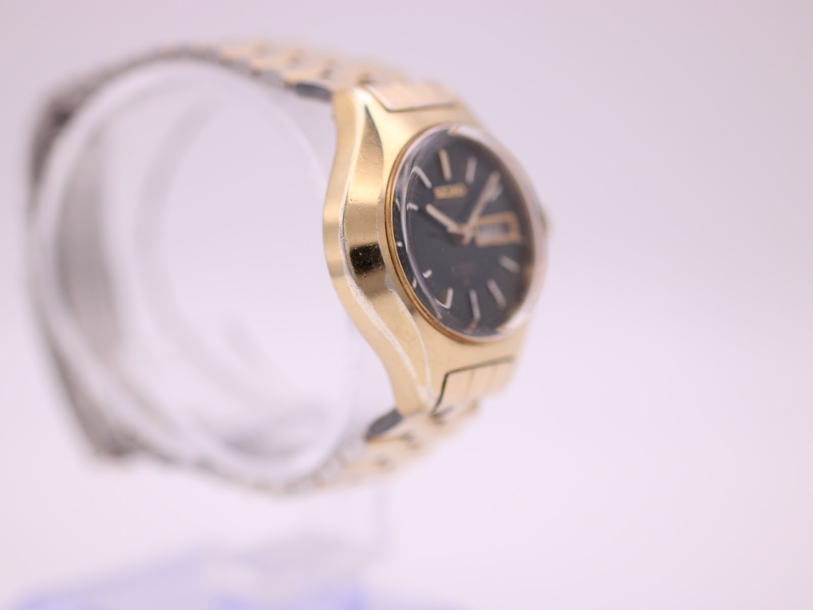 Left side profile of the gold-toned Seiko cushion case and integrated bracelet.