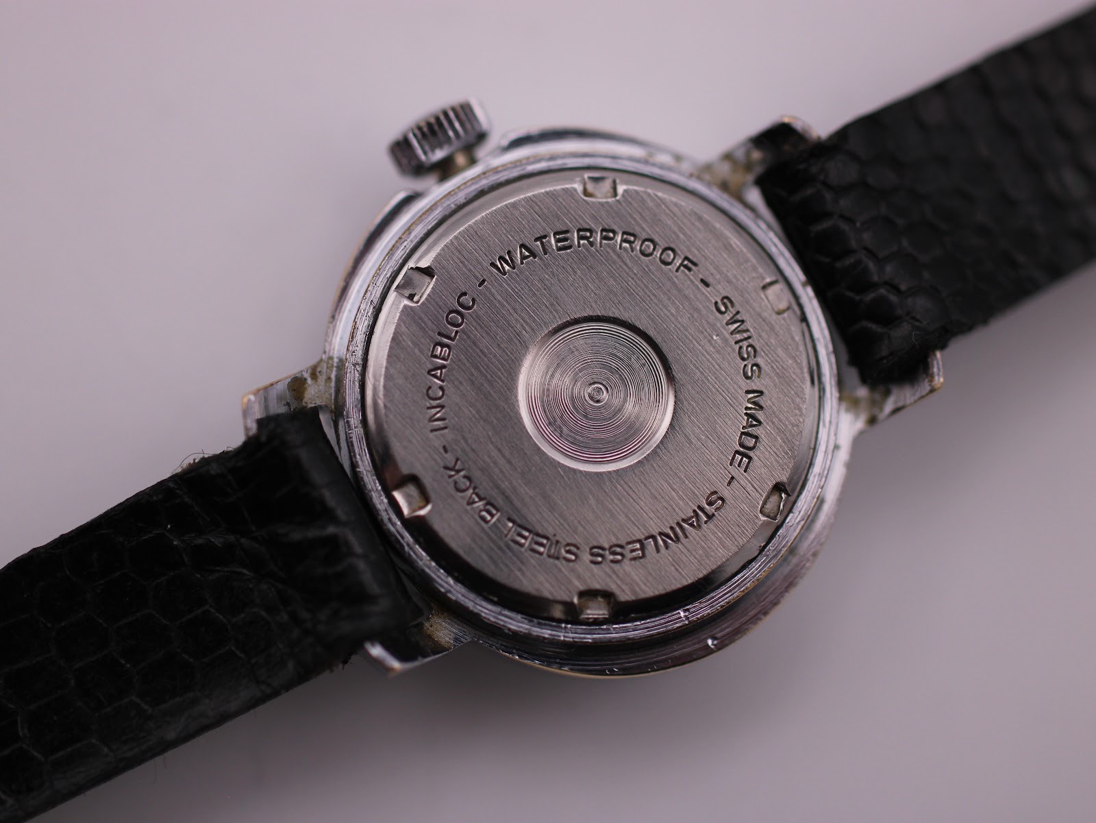 Detailed close-up of the Craftsman watch case back engraving, centred on the brushed stainless steel.