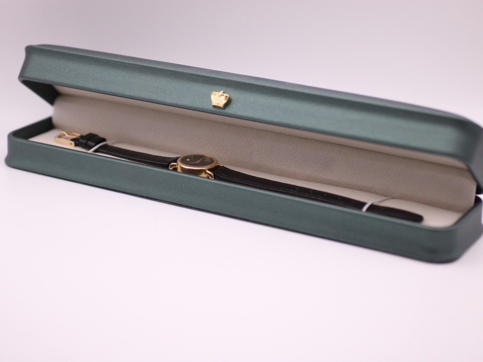 Raymond Weil watch displayed in an open green presentation box (studio prop).
