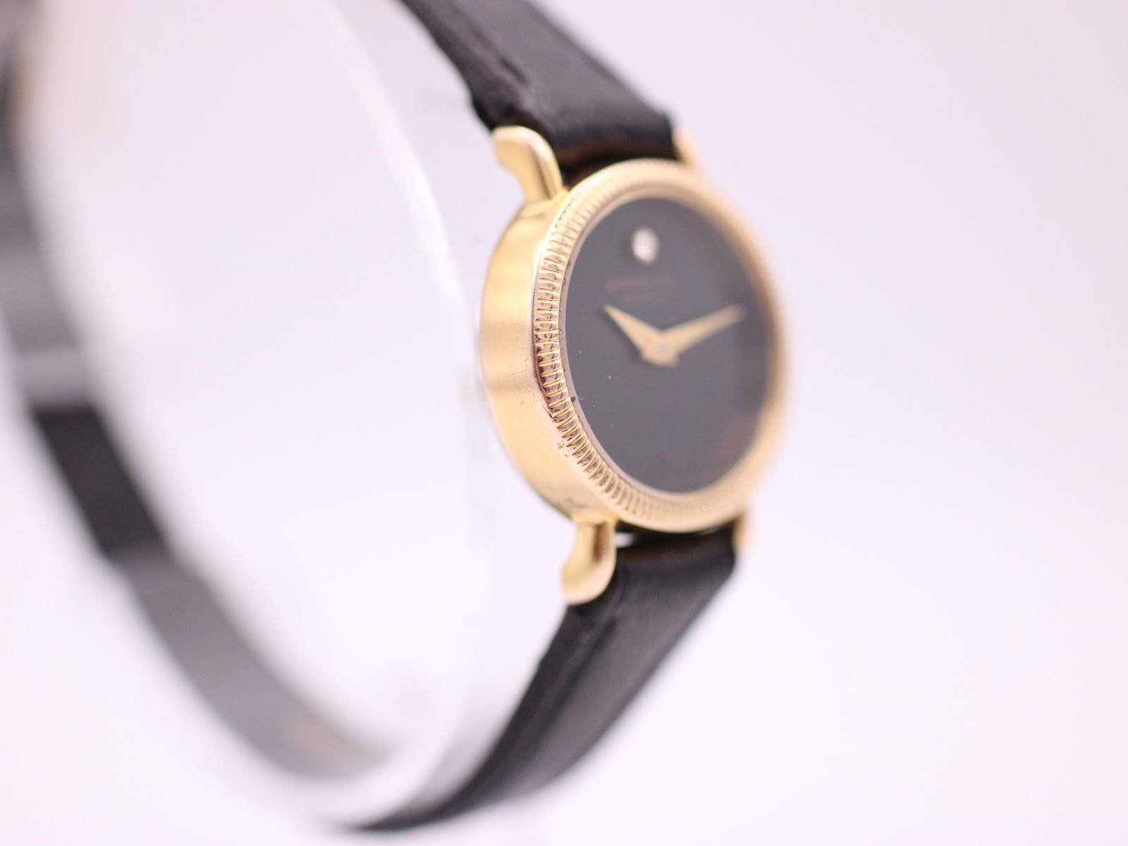 Side view of Raymond Weil watch, showing the slim profile and gold tone case.