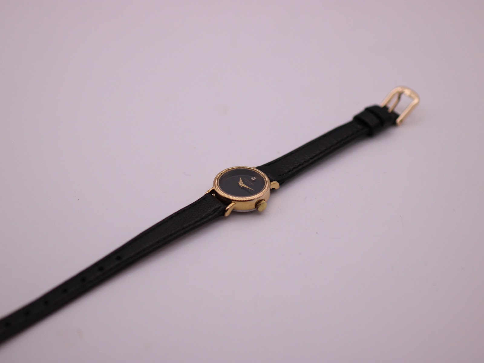 Full overhead view of the Raymond Weil watch with black leather strap extending.
