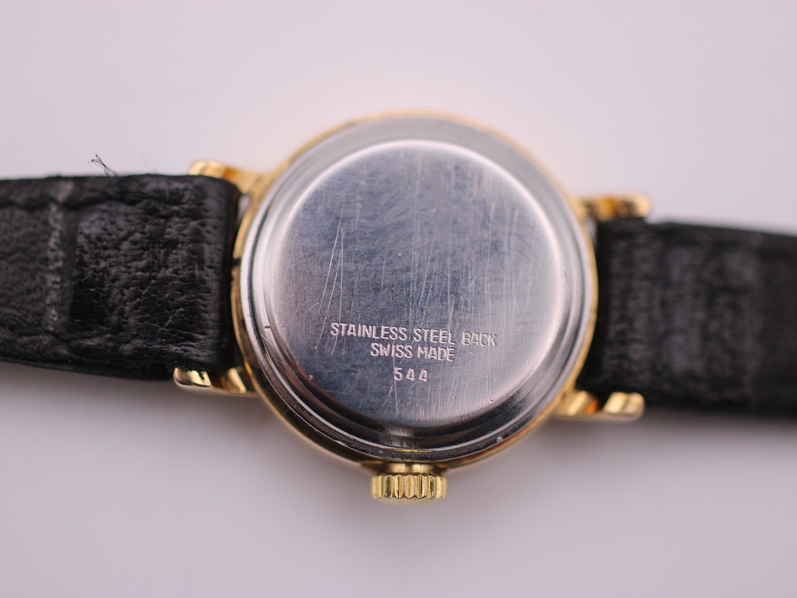 Close-up of the stainless steel case back, engraved "STAINLESS STEEL BACK SWISS MADE 544".