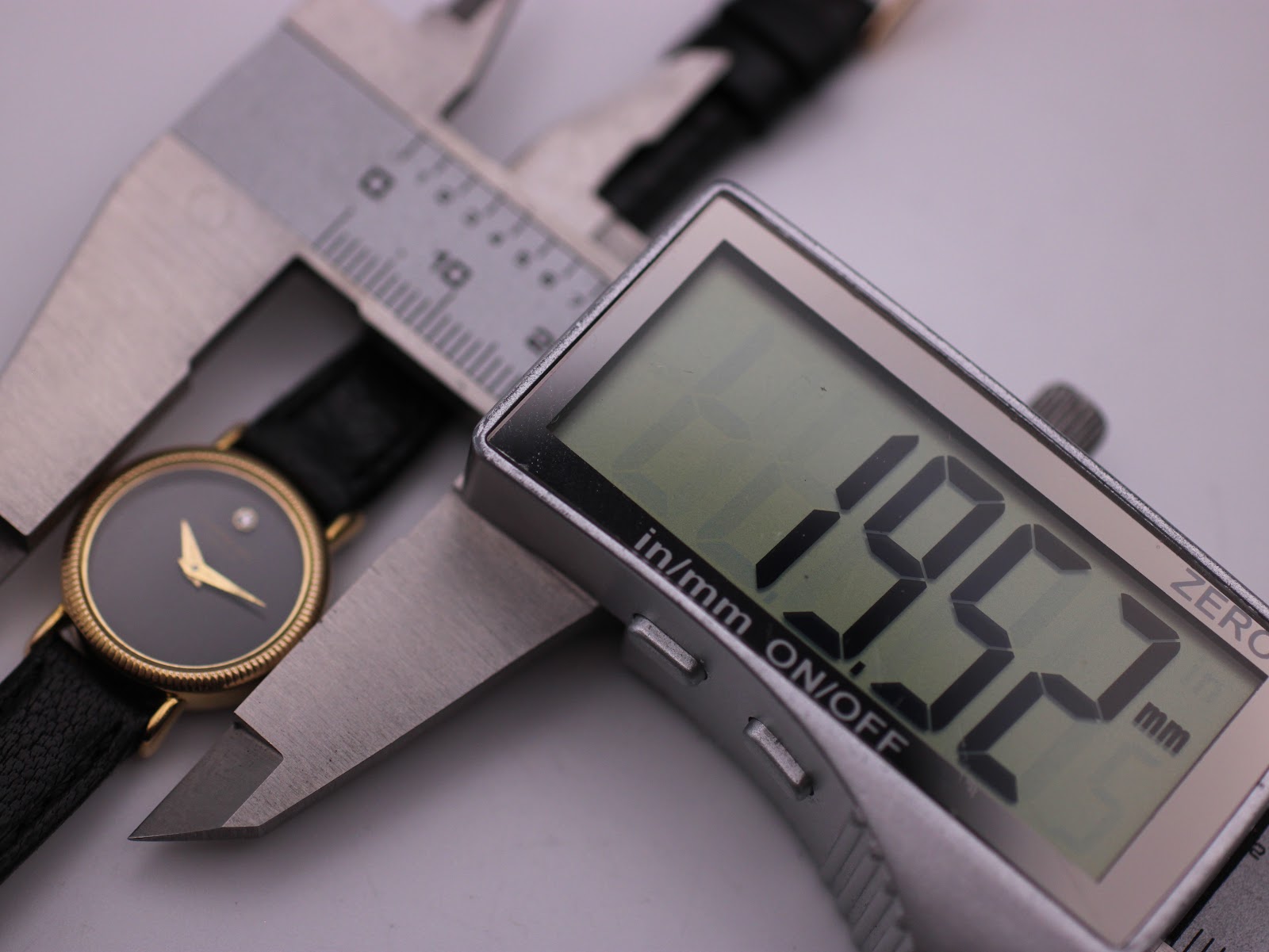 Digital caliper measuring the watch case, displaying 19.52mm.