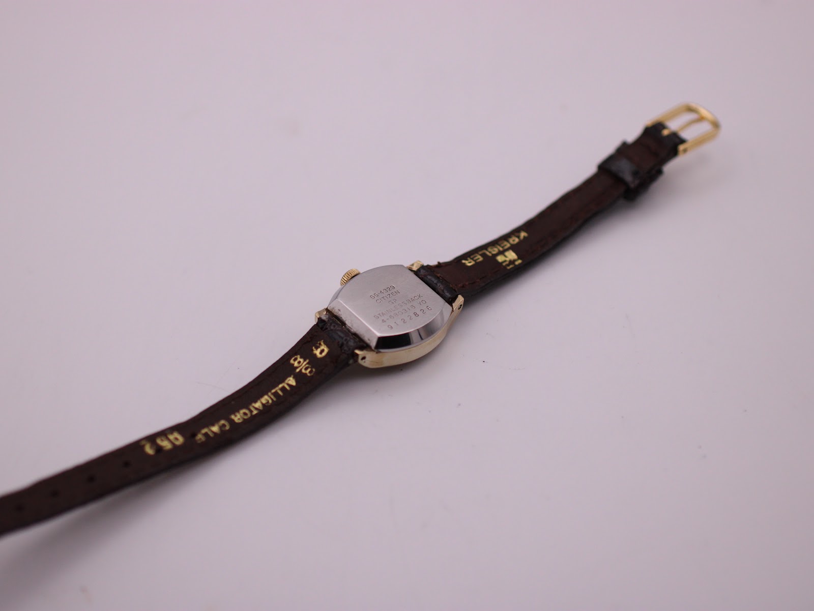 Rear view of the Citizen watch, focusing on the stainless steel case back and the brown leather strap with its texture.