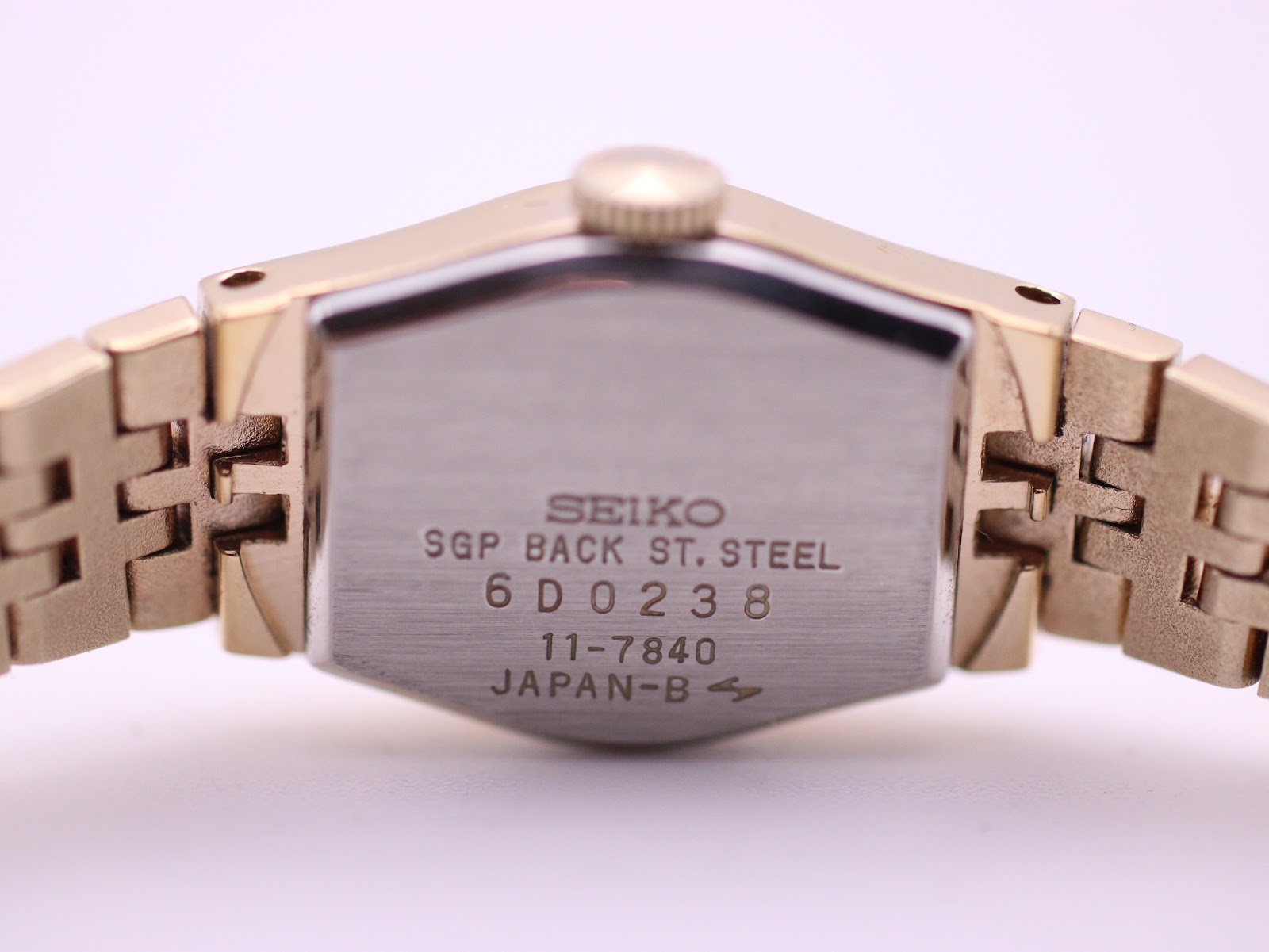 Close-up of the watch's stainless steel case back, showing "SEIKO SGP BACK ST. STEEL", serial "6D0238", model "11-7840", and "JAPAN-B".