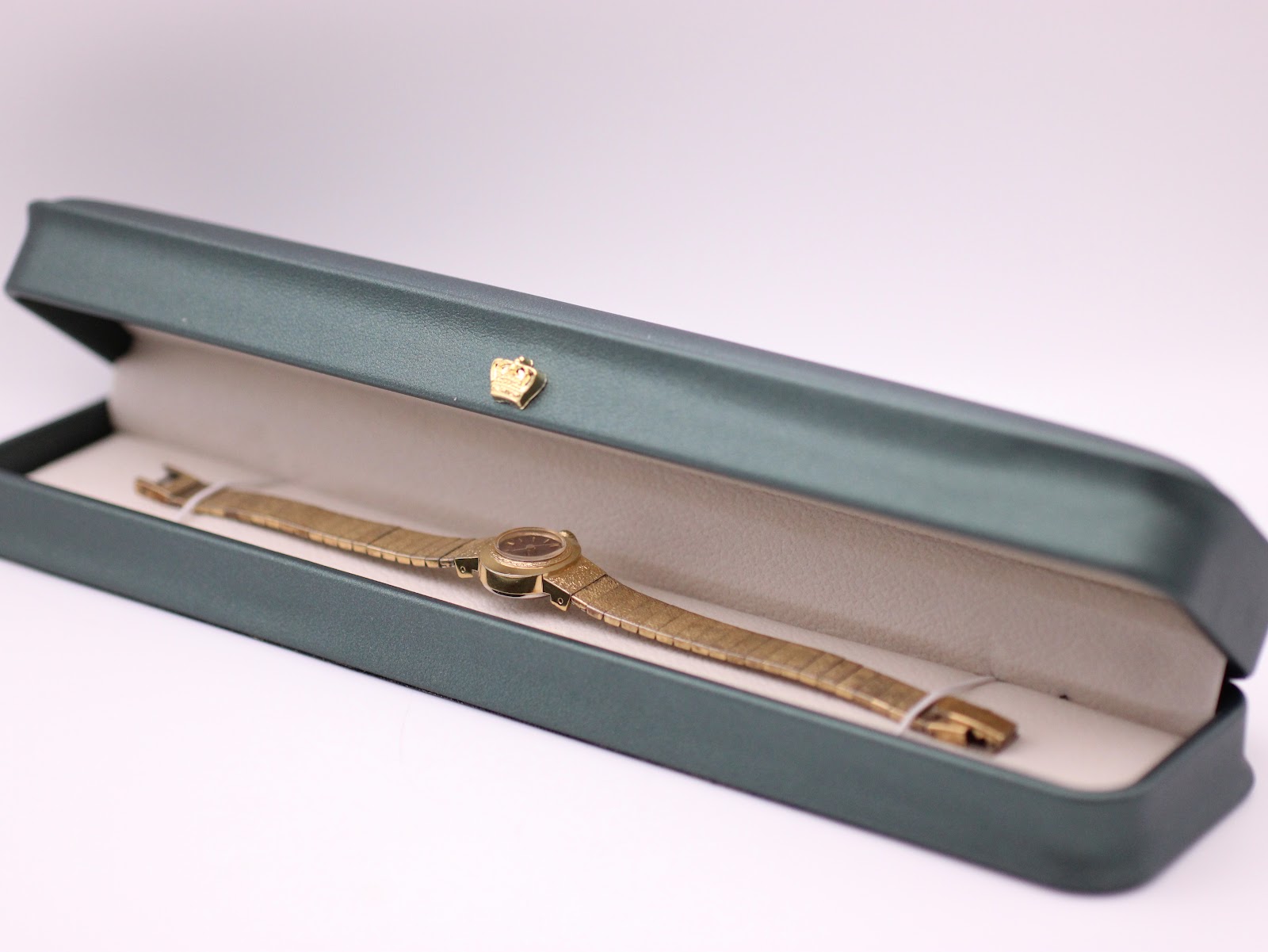 Side view of the vintage Seiko watch presented in a generic green leatherette display box.