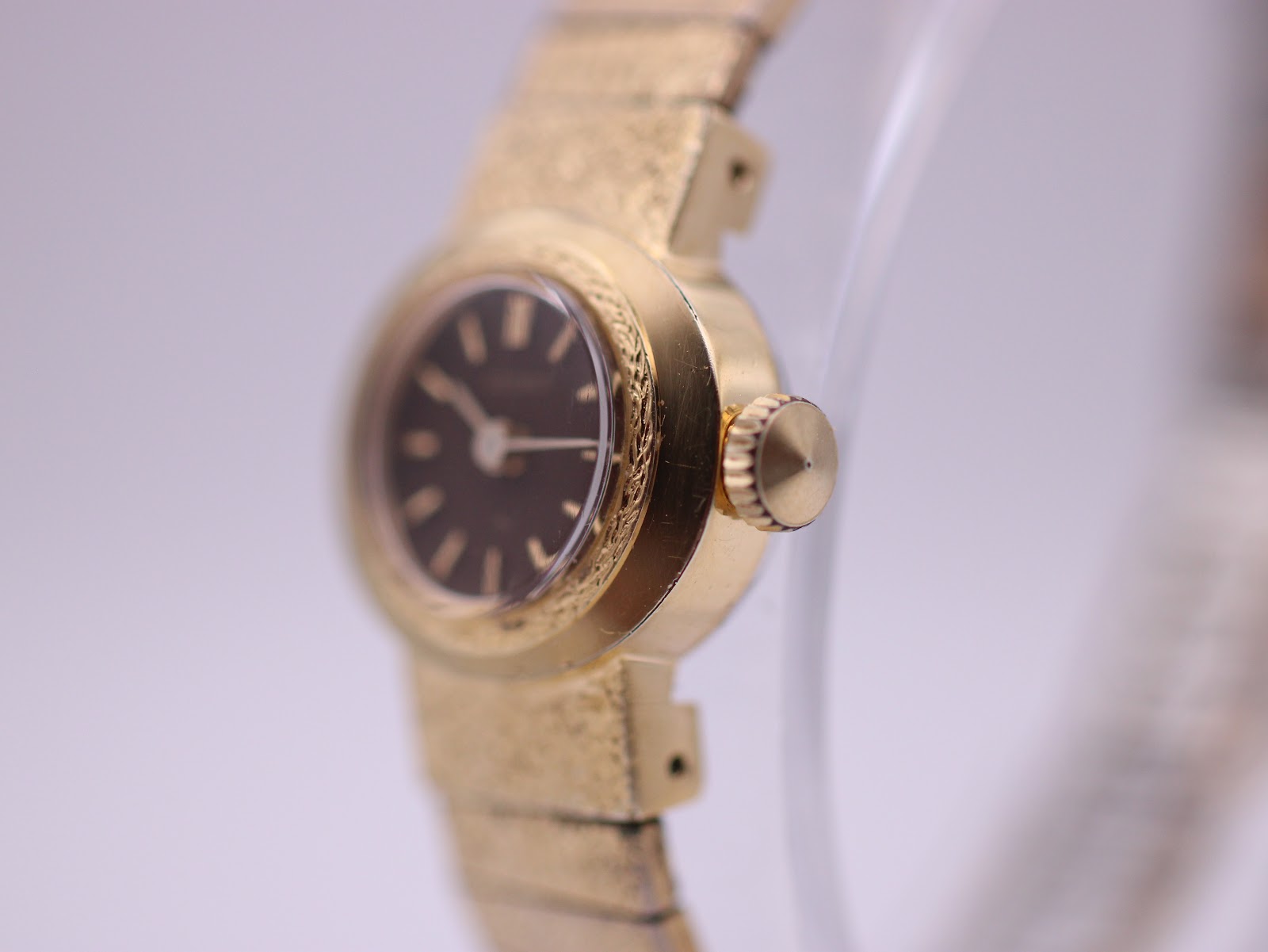 Right-side profile of the gold-plated Seiko watch case, showing the textured bezel, crown, and gold-tone bracelet links.