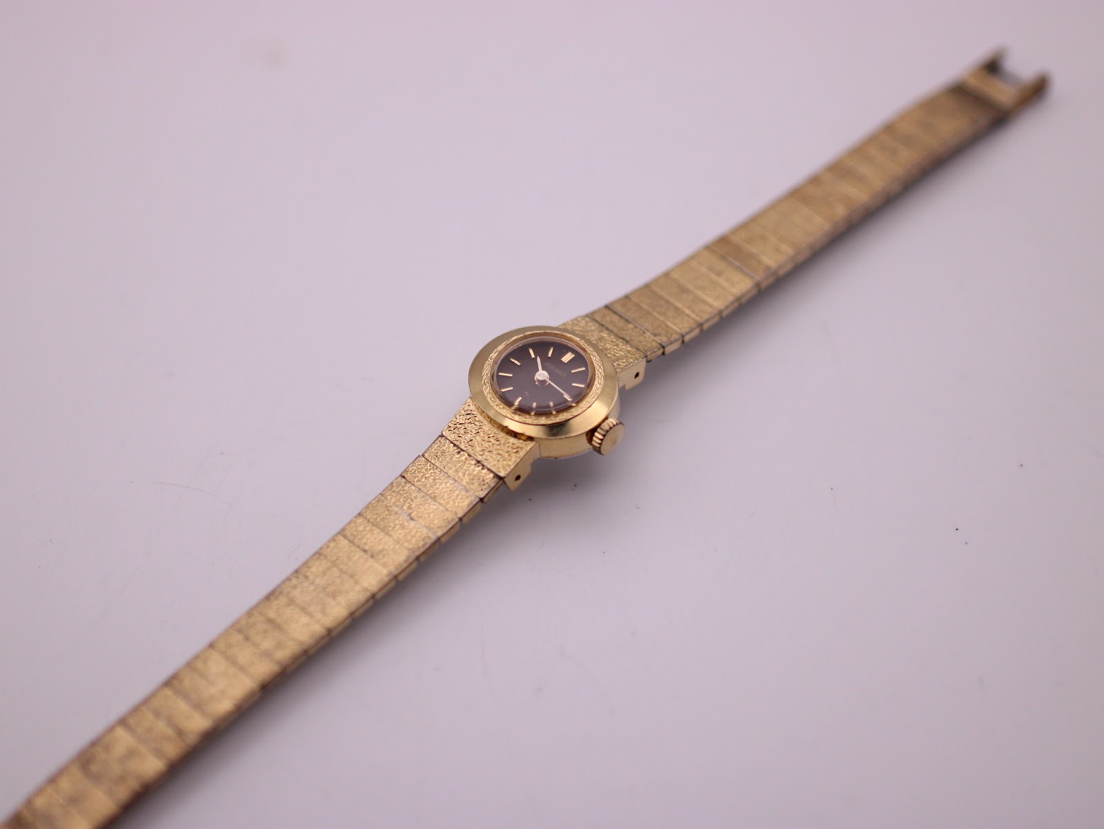 Overhead view of the vintage Seiko watch with its gold-tone expanding bracelet fully extended.