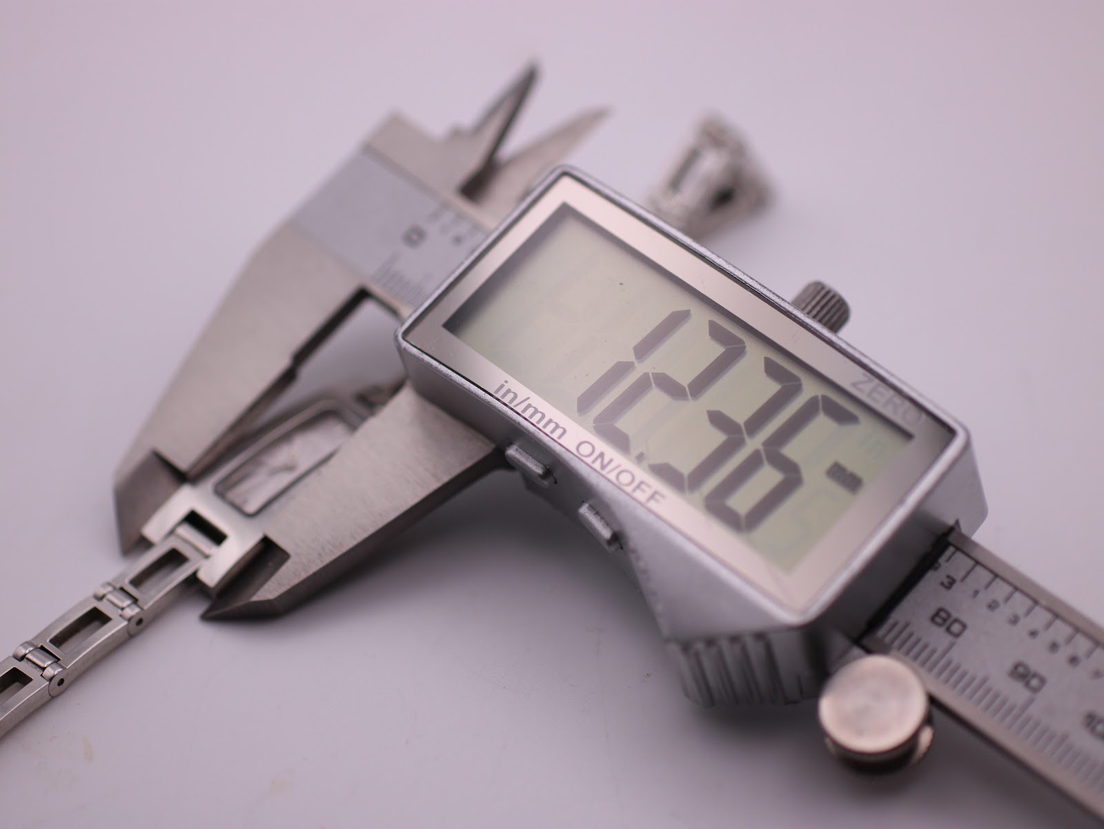 Digital caliper measuring the width of the Gucci 3900L watch case, showing 12.36mm.