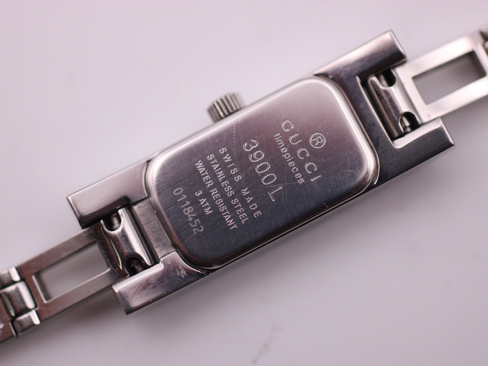 Detailed close-up of the Gucci 3900L watch case back showing model number 3900L, serial number 0118452, and 'SWISS MADE'.
