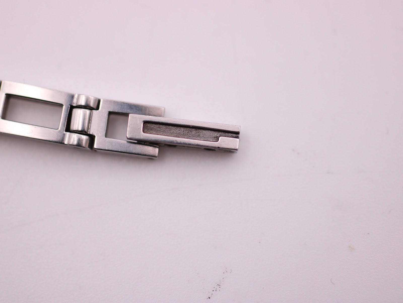 Close-up of the deployment clasp on the Gucci 3900L integrated stainless steel bracelet.